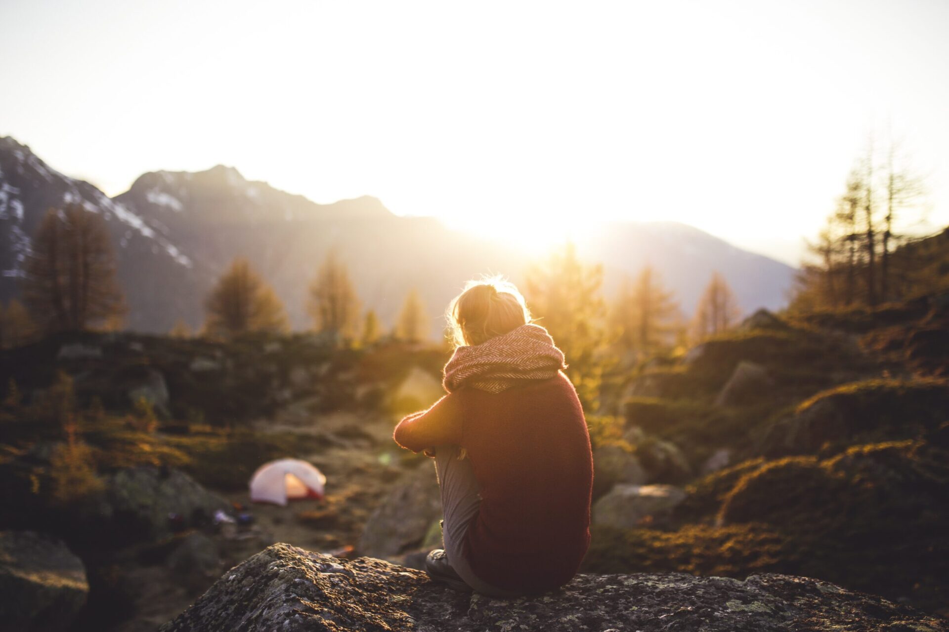 A hiker watching sunrise near a mountain