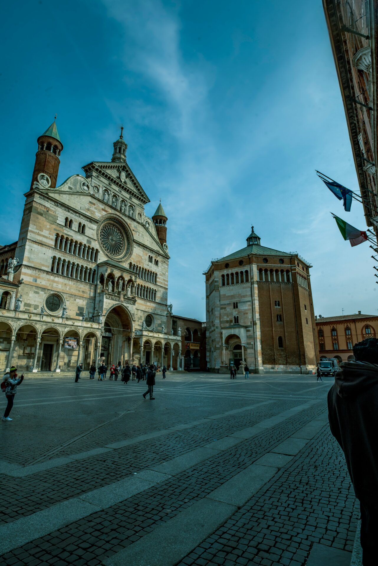 People walking outside the Cremona Cathedral in Italy