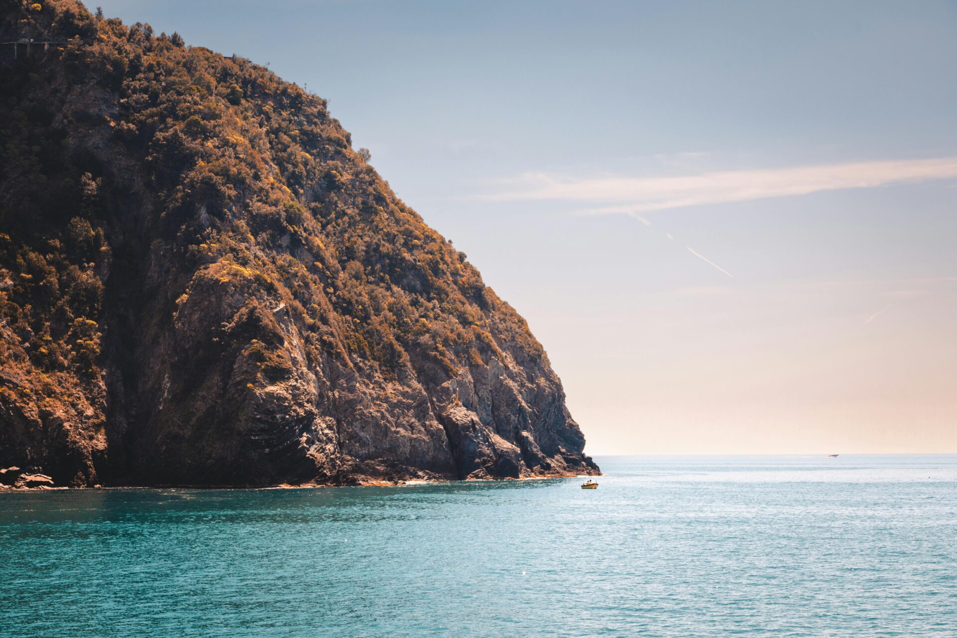 Beautiful view of Liguria's Western Riviera, with crystal-clear water gently lapping against dramatic rocky cliffs