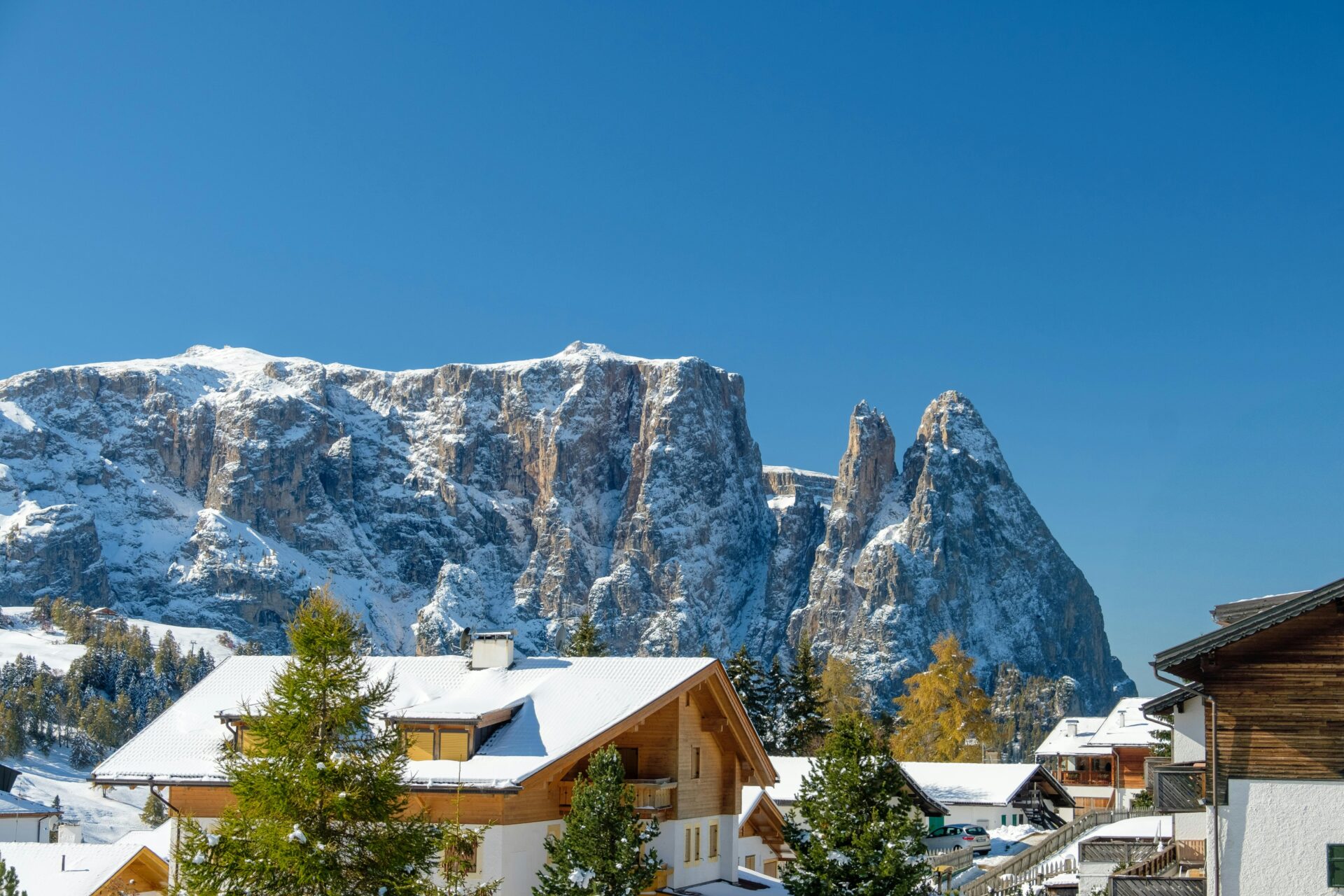 Snow-Covered Mountains Behind Wooden Chalet. Selva di Val Gardena, Trentino-South Tyrol, Italy