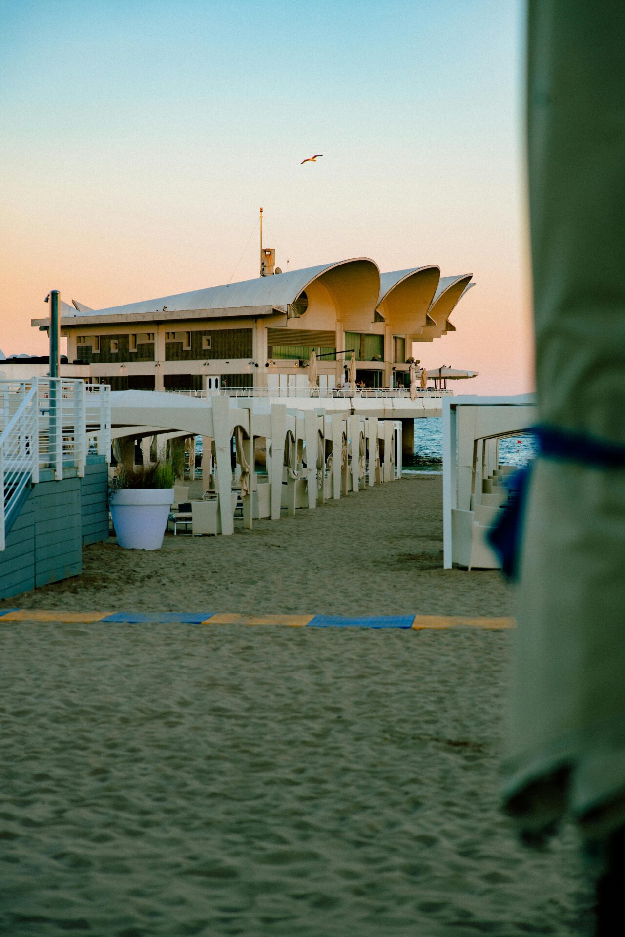 Shell-shaped Terrazza a Mare restaurant in Lignano Sabbiadoro, Italy, extending over the sea with stunning coastal views