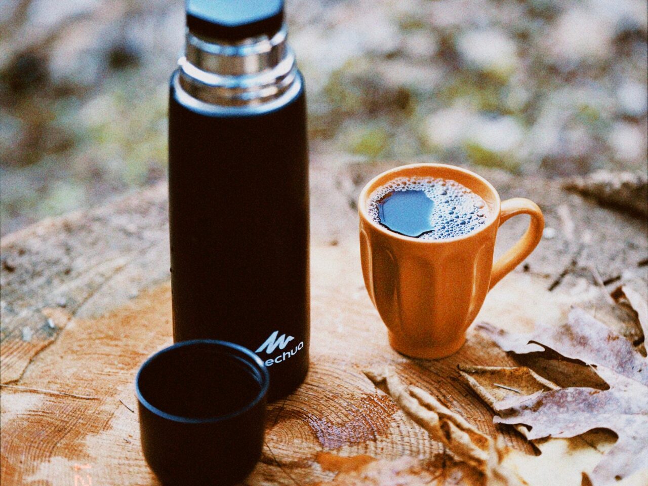 Two mugs with a travel thermos or flask