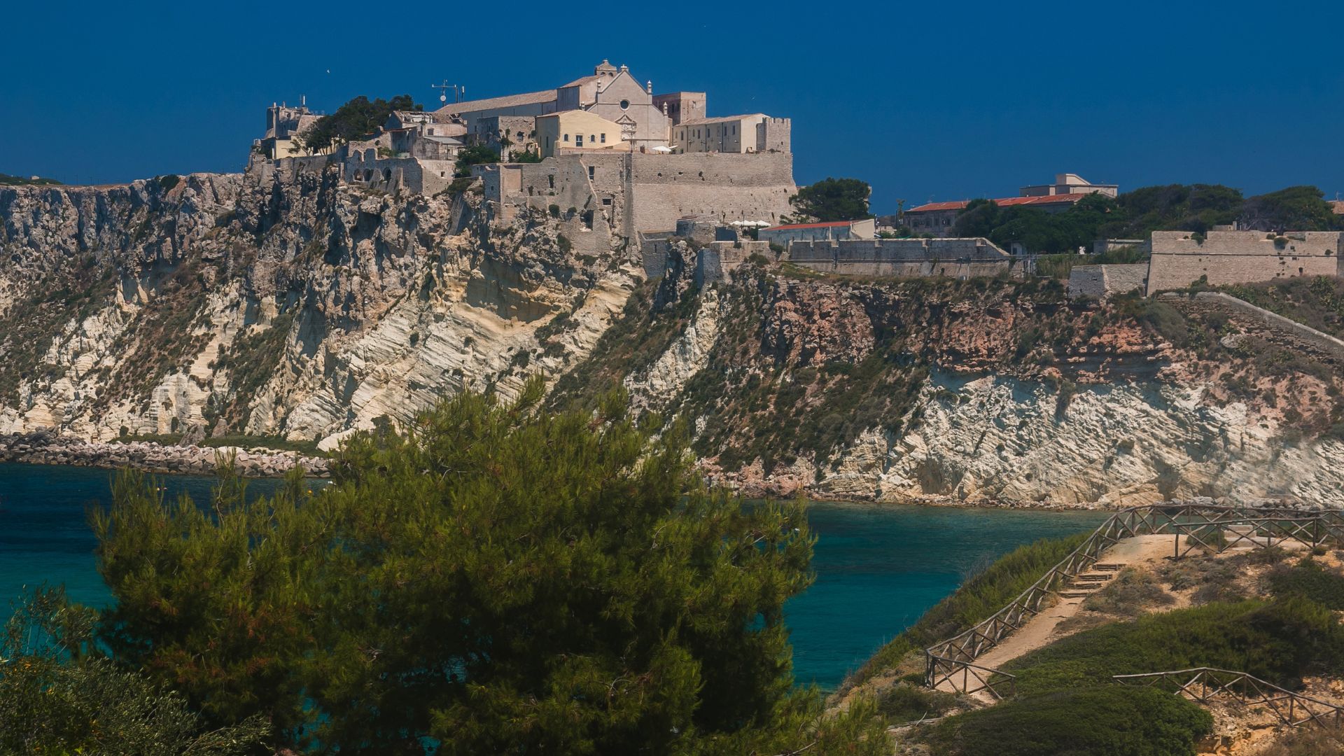 The image shows the Abbey of Santa Maria a Mare, located on the island of San Nicola, part of the Tremiti Islands archipelago in the Gargano National Park, Italy. 