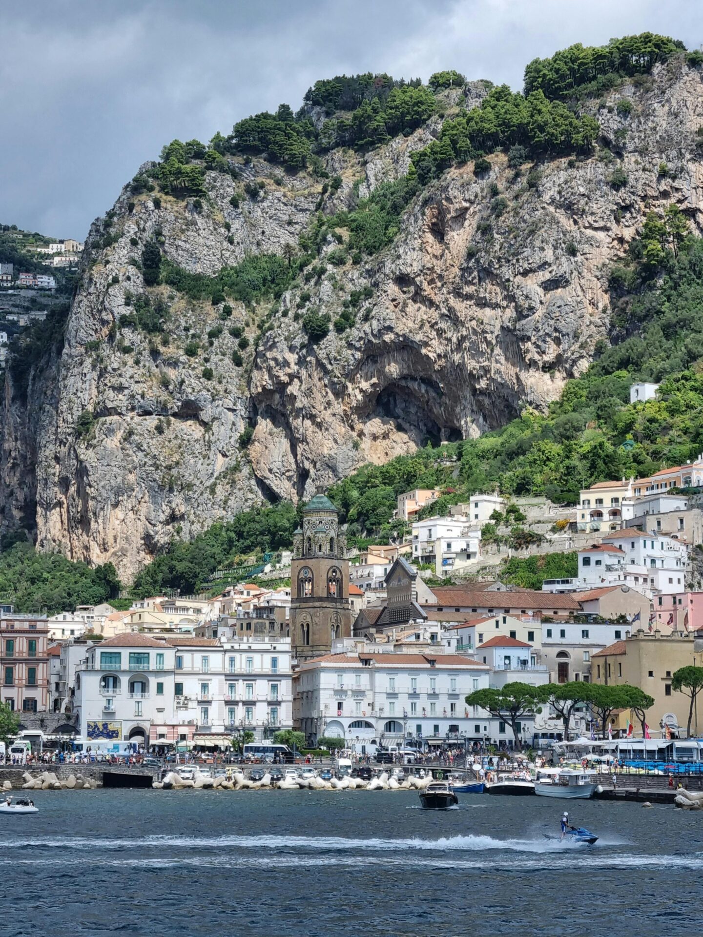 Amalfi Coast with numerous boats in the water and a village nestled along the cliffs.