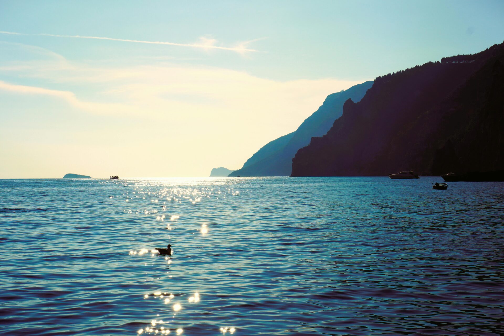 Amalfi Coast view with a boat and a duck floating on the calm sea