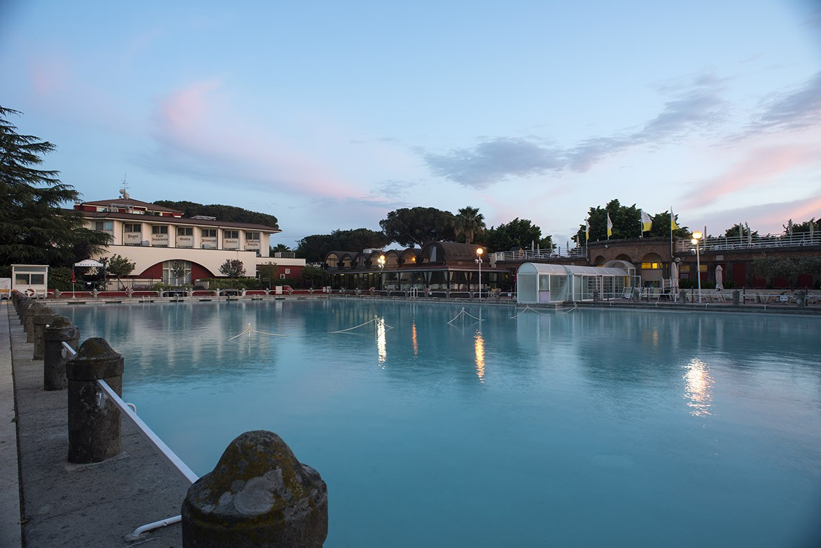 Bagno del Papa in Viterbo, Italy, an ancient thermal bath complex once used by papal figures, showcasing historic stone structures surrounded by greenery and remnants of Roman-era spa architecture.