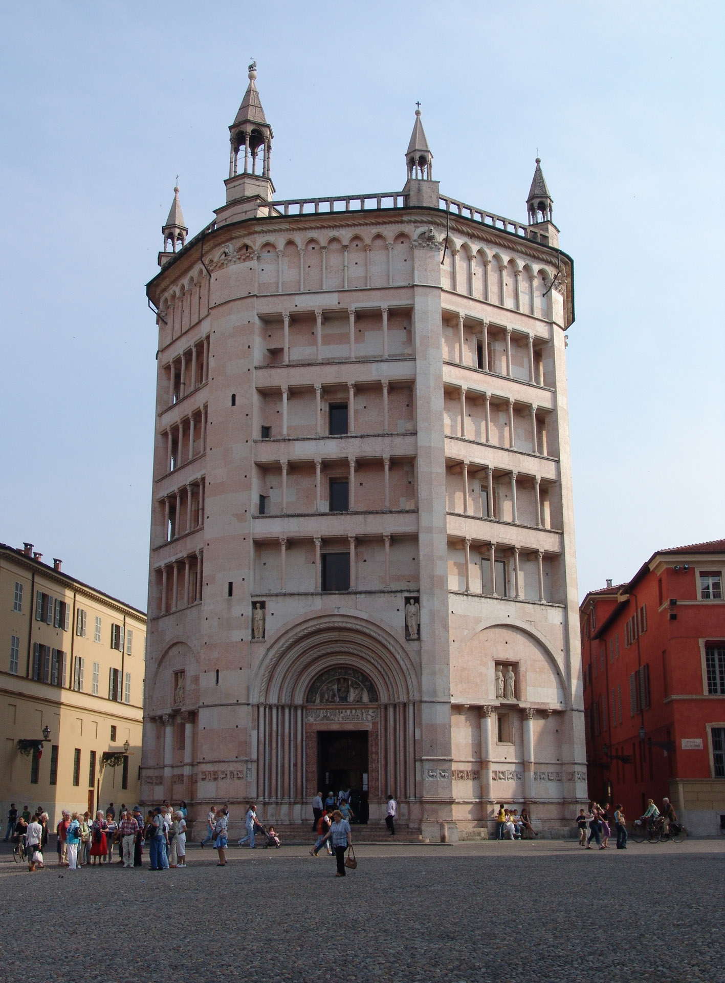 The Baptistery of Parma, Italy, a magnificent octagonal marble building with intricate medieval carvings and stunning frescoed interiors.