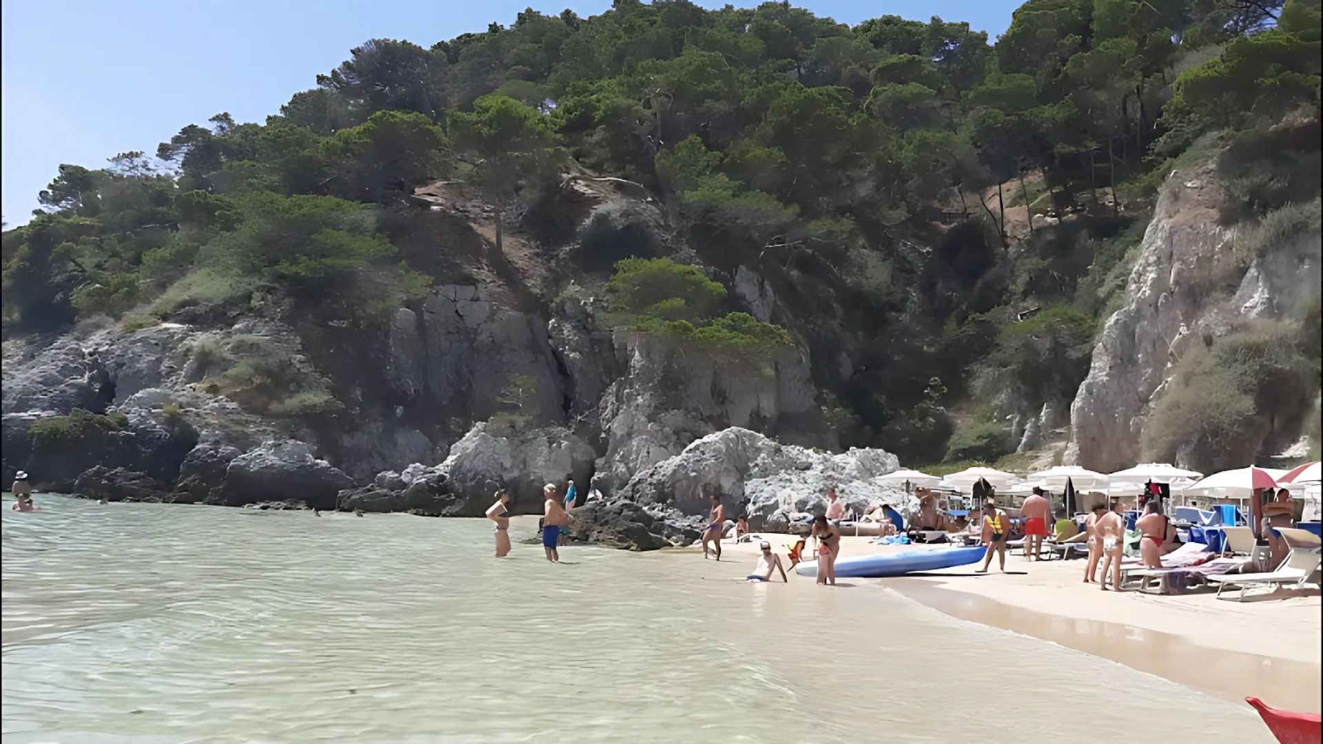 Image shows the beach in Cala delle Arene, San Domino, Tremiti Islands, Italy with people.