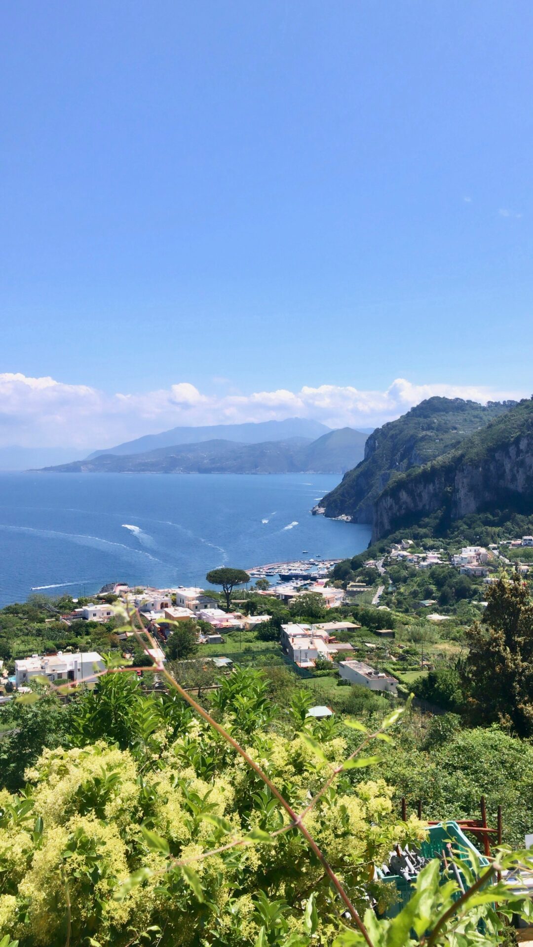Aerial view of Capri showing the island’s rugged coastline, turquoise waters, and hillside villages.