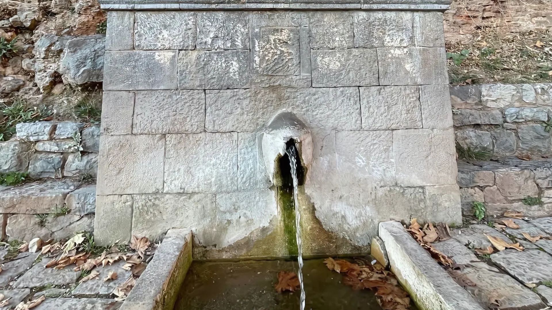 The image shows the Castalian Spring in Delphi, Greece
