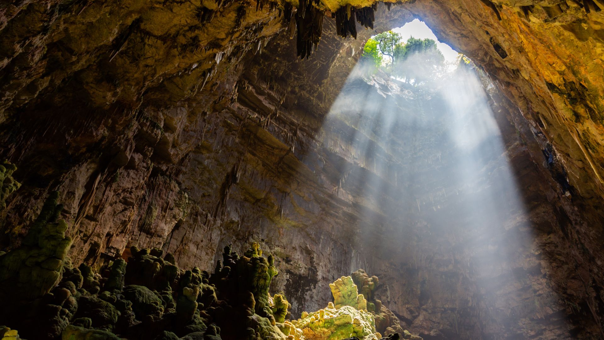 A sunlit cavern within the Castellana Caves, showcasing its impressive geological formations.