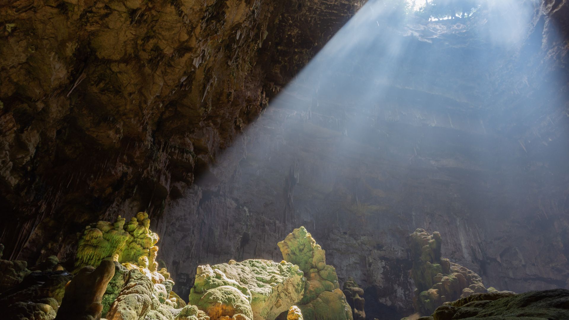 A sunlit cavern within the Castellana Caves, showcasing its impressive geological formations.