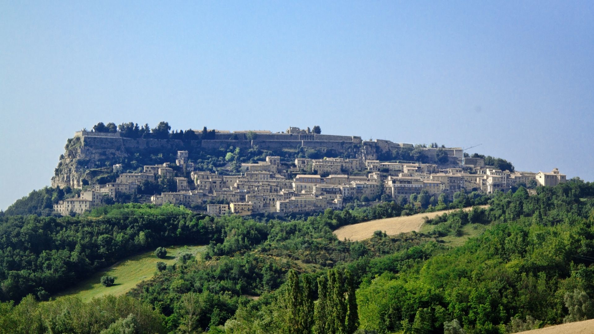 Image shows the Fortress of Civitella del Tronto perched on a rocky cliff in Italy's Abruzzo region.