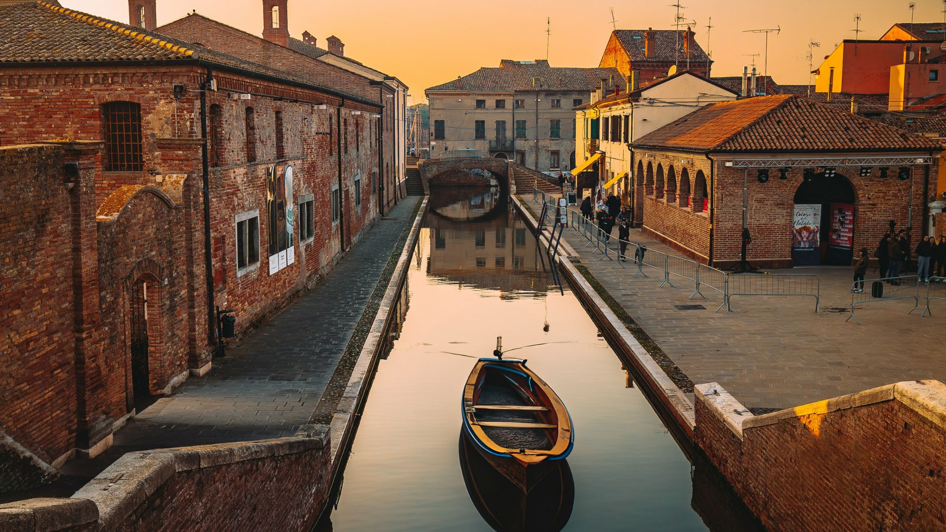 The image shows a canal in Comacchio, Italy.