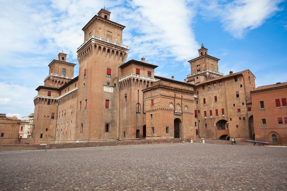 The Este Castle architecture features red terracotta bricks and white balustrades, with interior spaces including prisons and rooms used for court games.
