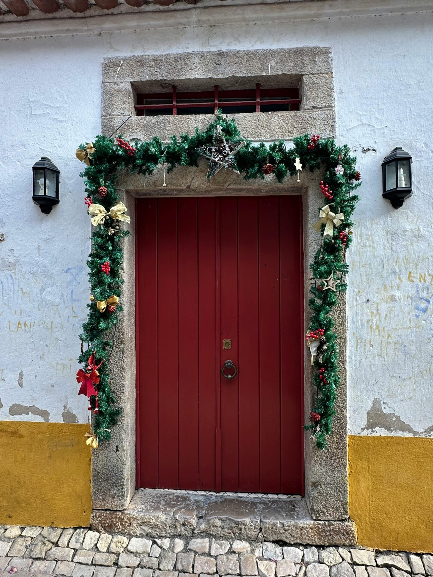 Festive Red Door with Christmas Decorations in Óbidos, Portugal.