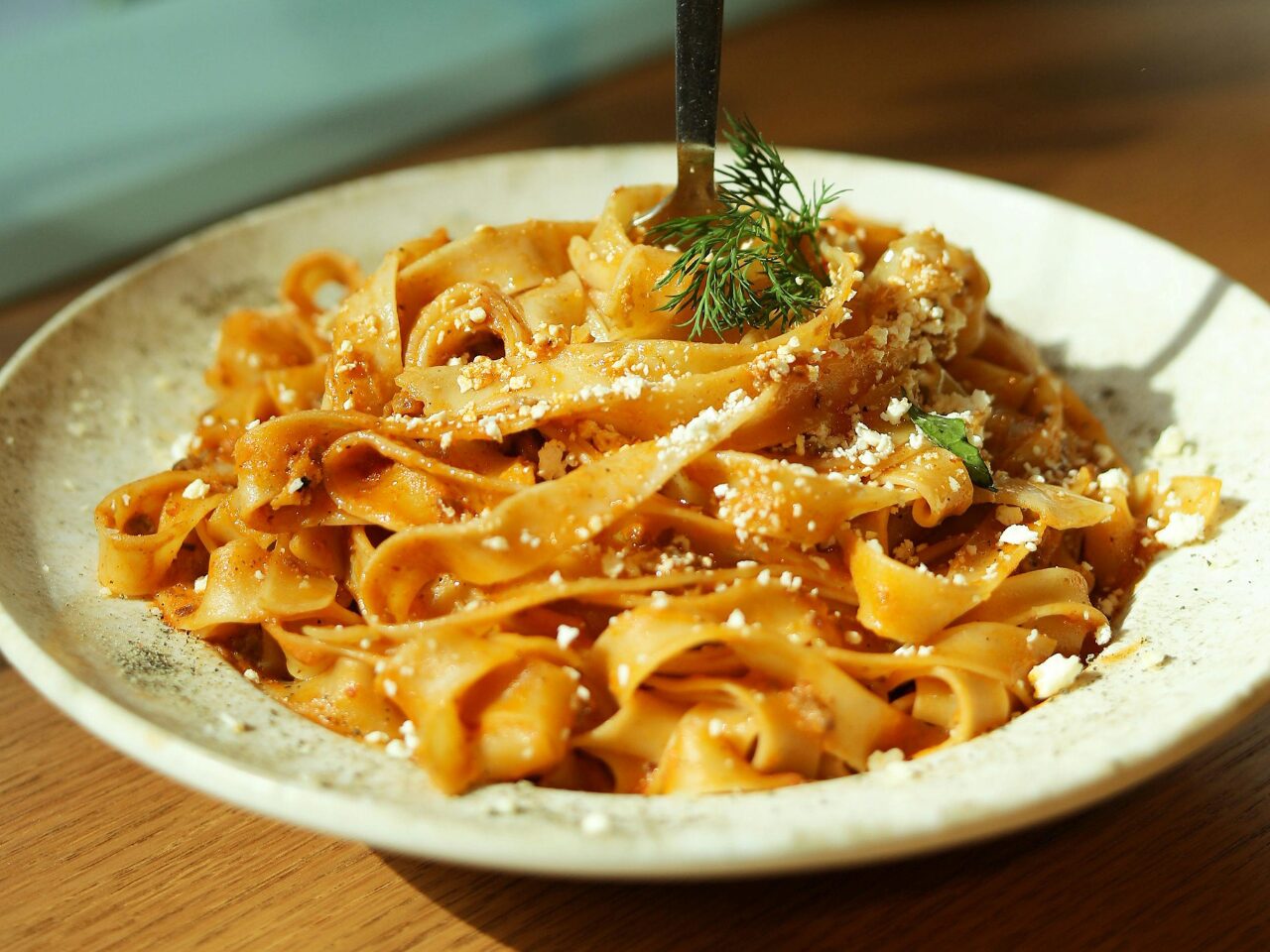 Flat pasta dish with tomato sauce and parmesan cheese