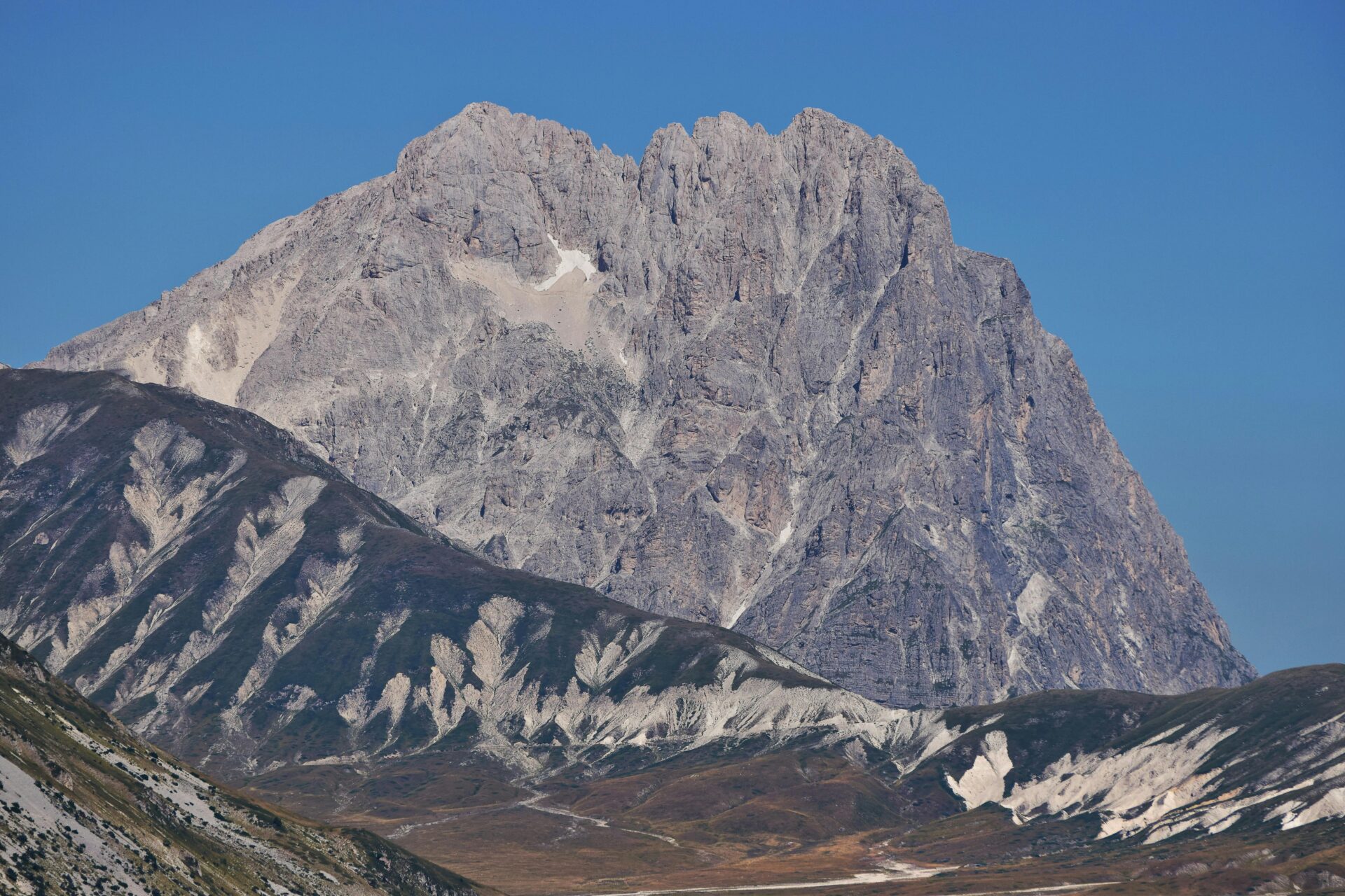 Majestic peaks of Gran Sasso e Monti della Laga National Park with lush valleys, rugged mountains, and scenic hiking trails under a clear blue sky