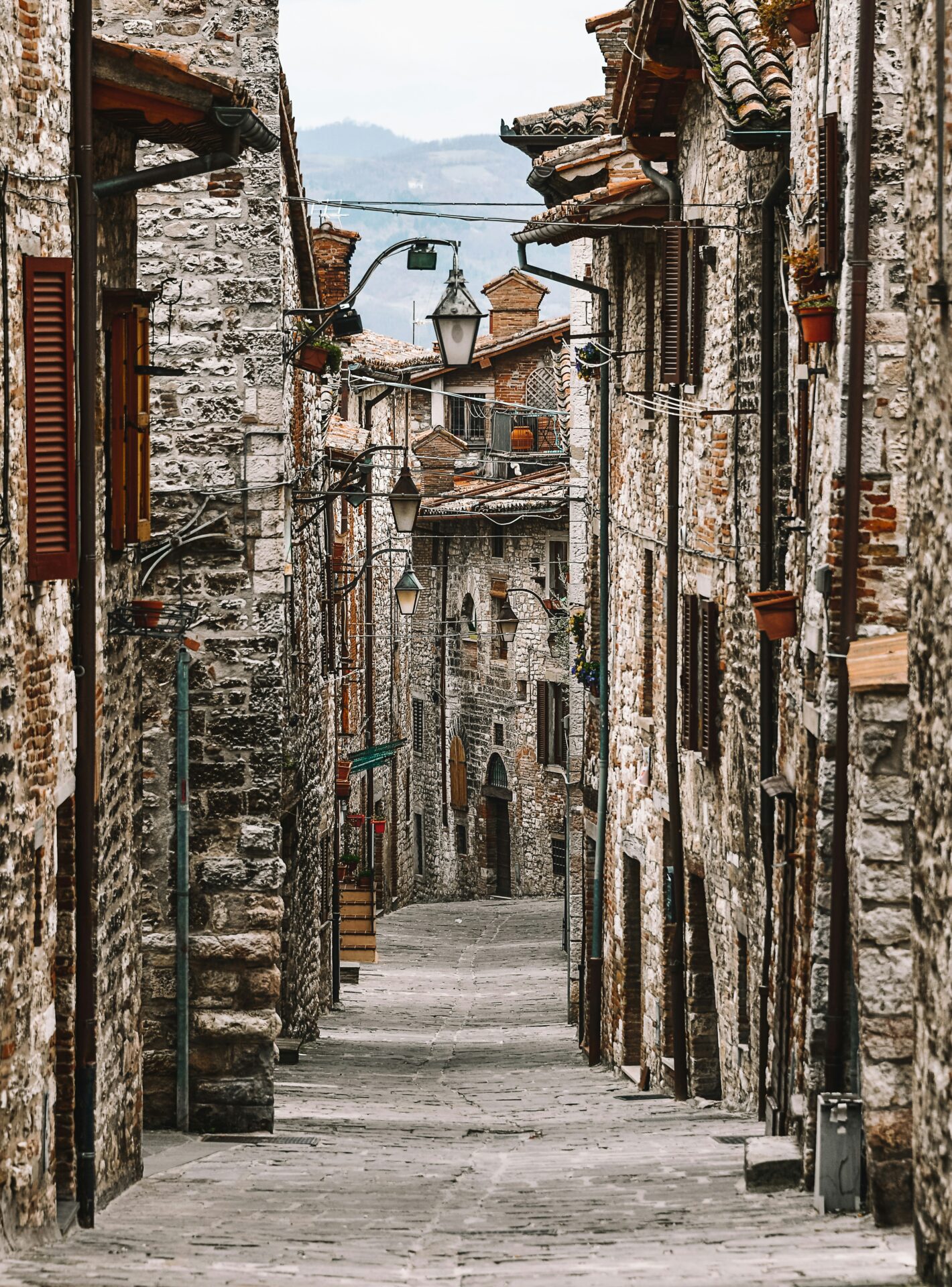 Blue and brown concrete building in Gubbio, a medieval town in the province of Perugia, showcasing Umbria’s historic architecture under bright daylight.