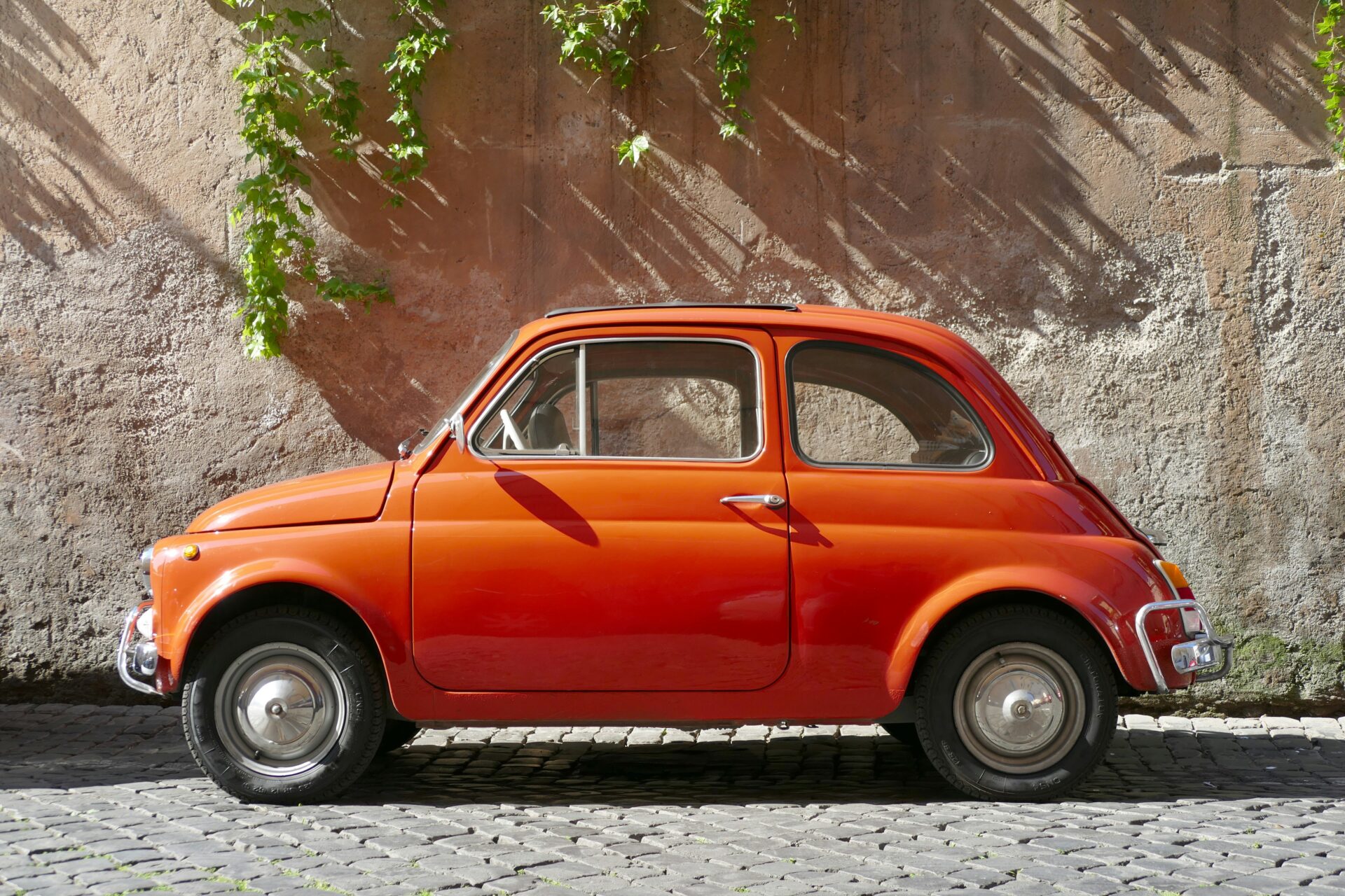 Red Italian car parked at the corner of a street