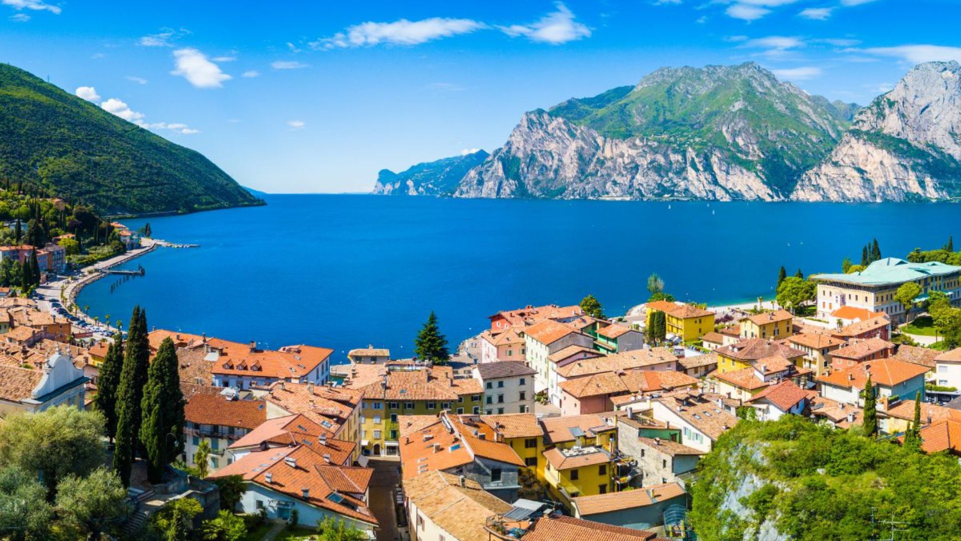 Aerial view of Lake Garda with colorful buildings and mountains.
