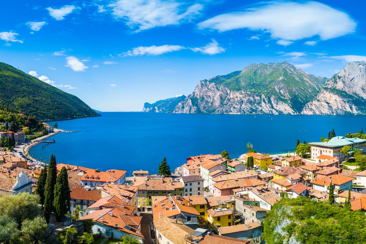 Aerial view of Lake Garda with colorful buildings and mountains.