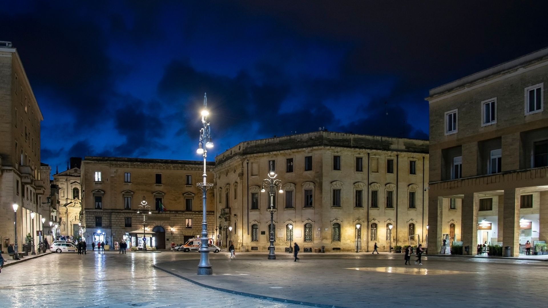 Night view of Piazza Sant'Oronzo in Lecce, featuring historic buildings and streetlights.