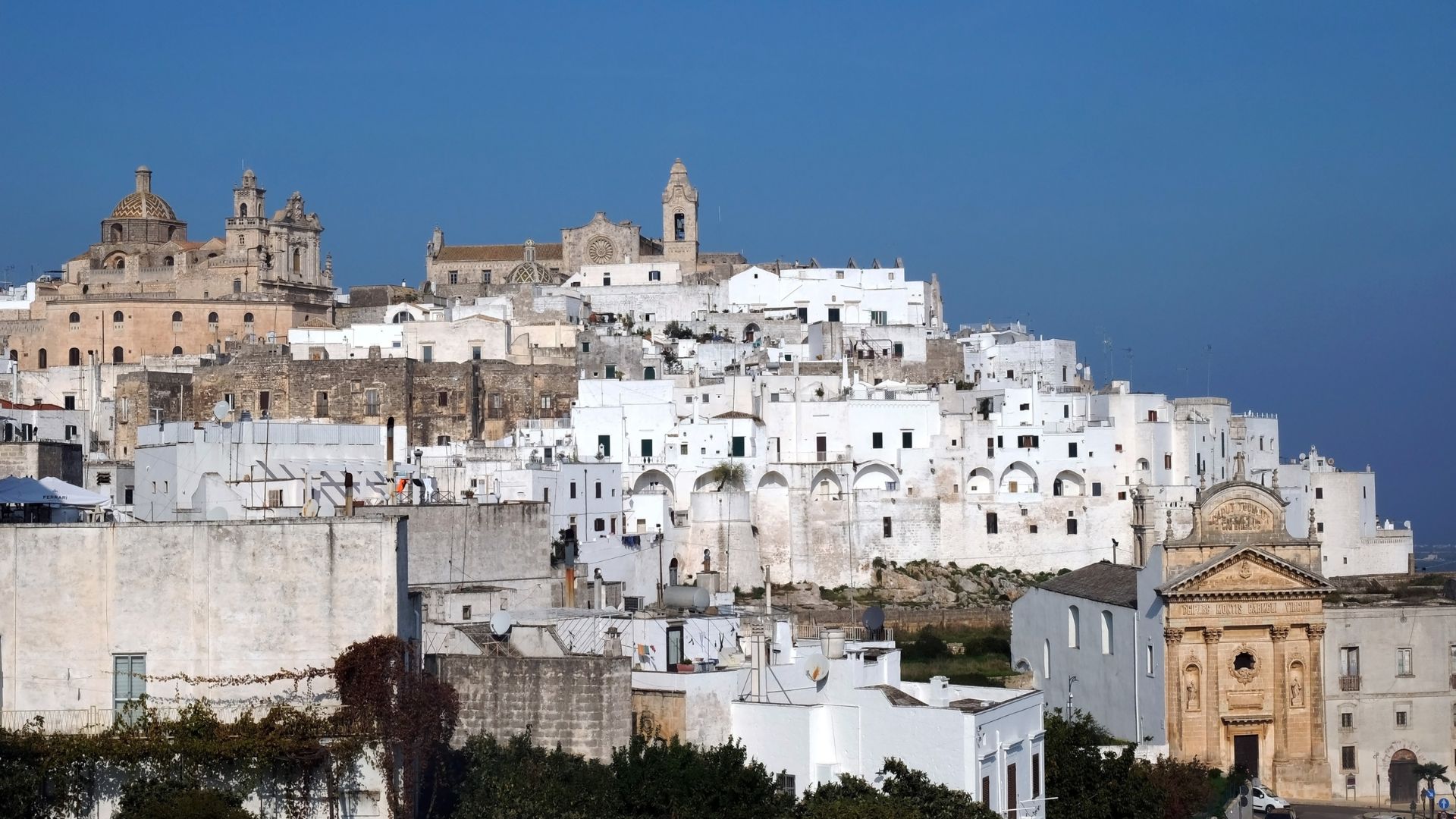 The image shows white houses in Ostuni, Puglia, Italy.