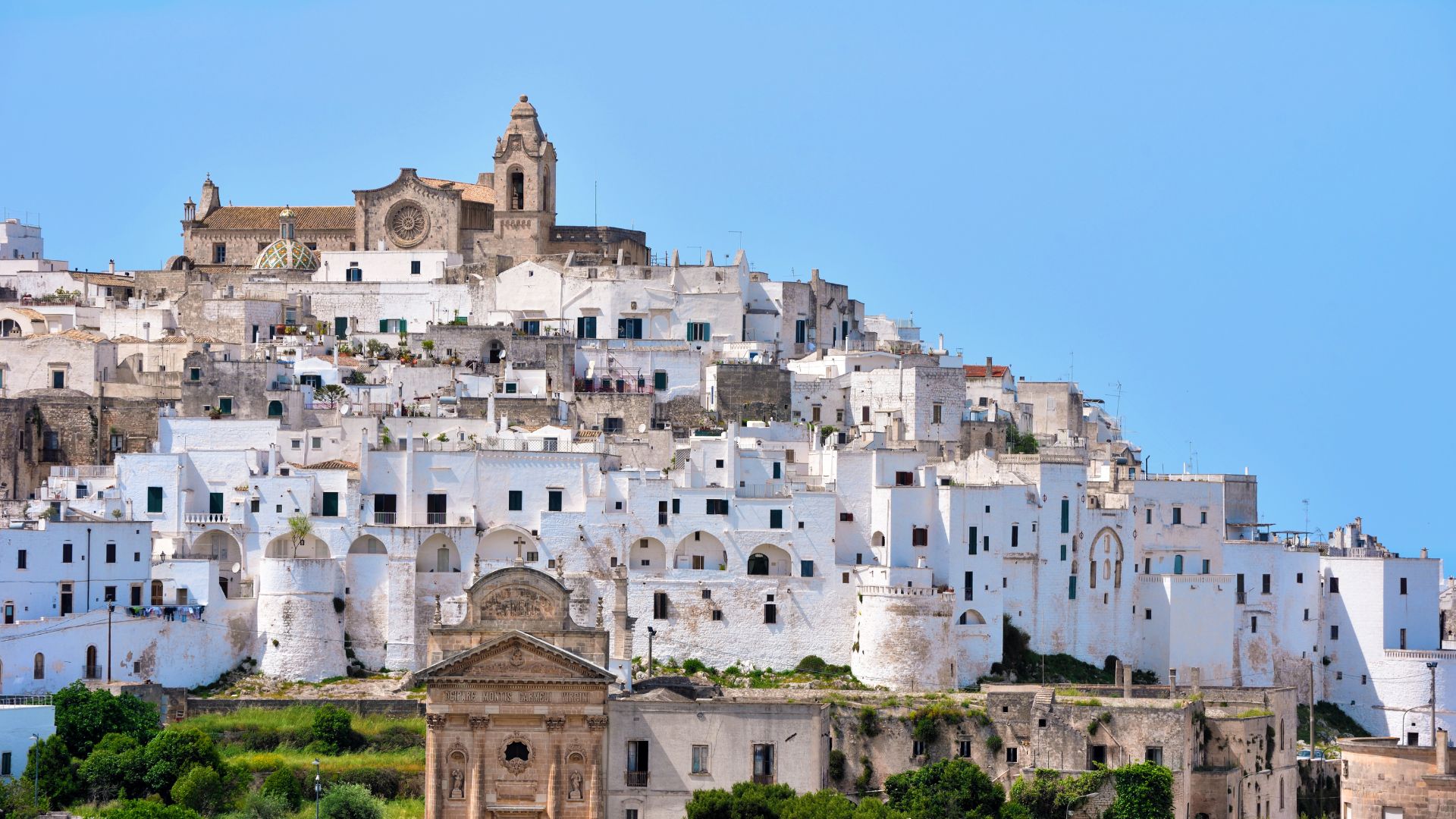 The image shows white houses in Ostuni, Puglia, Italy.