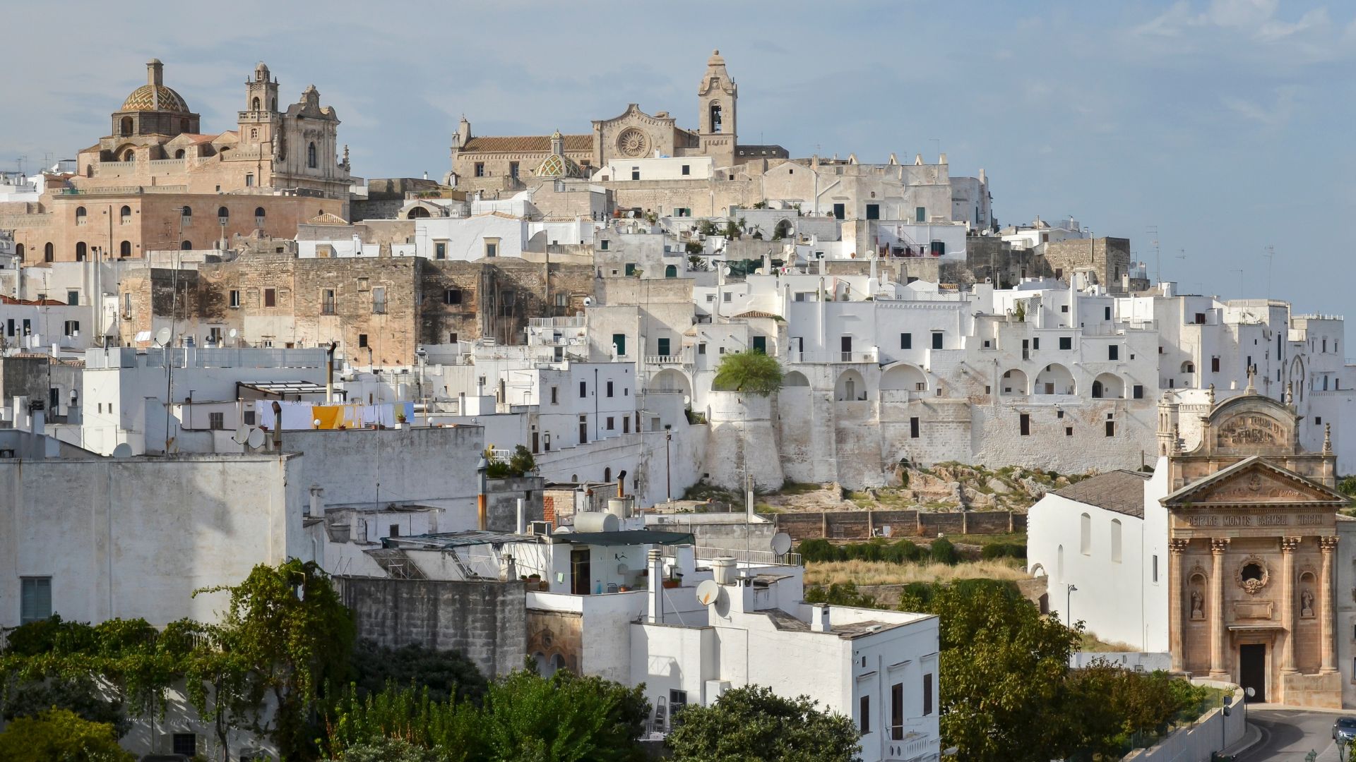 The image shows white houses in Ostuni, Puglia, Italy.