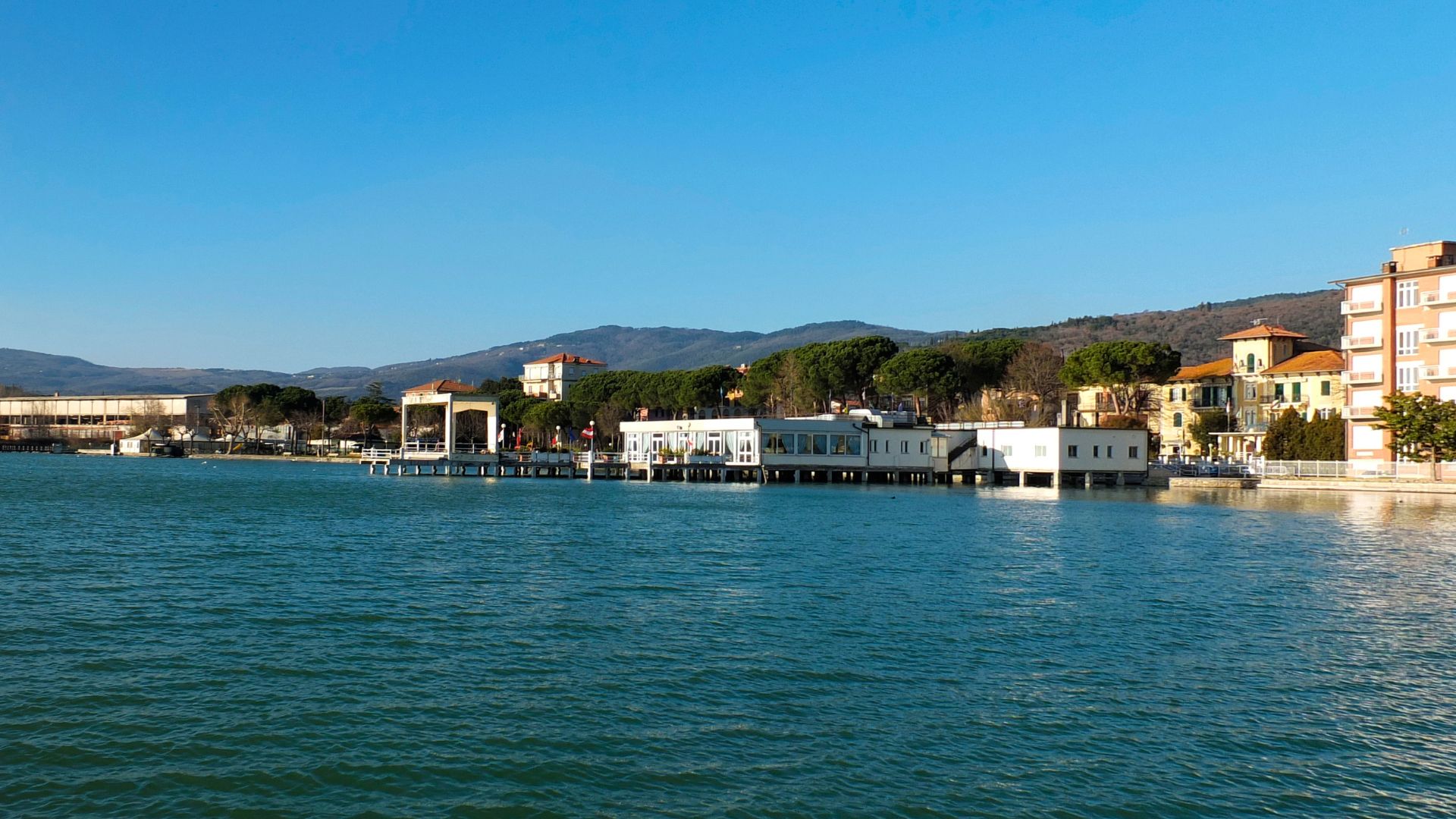 The image shows Lago Trasimeno and the town of Passignano sul Trasimeno in Umbria, Italy.