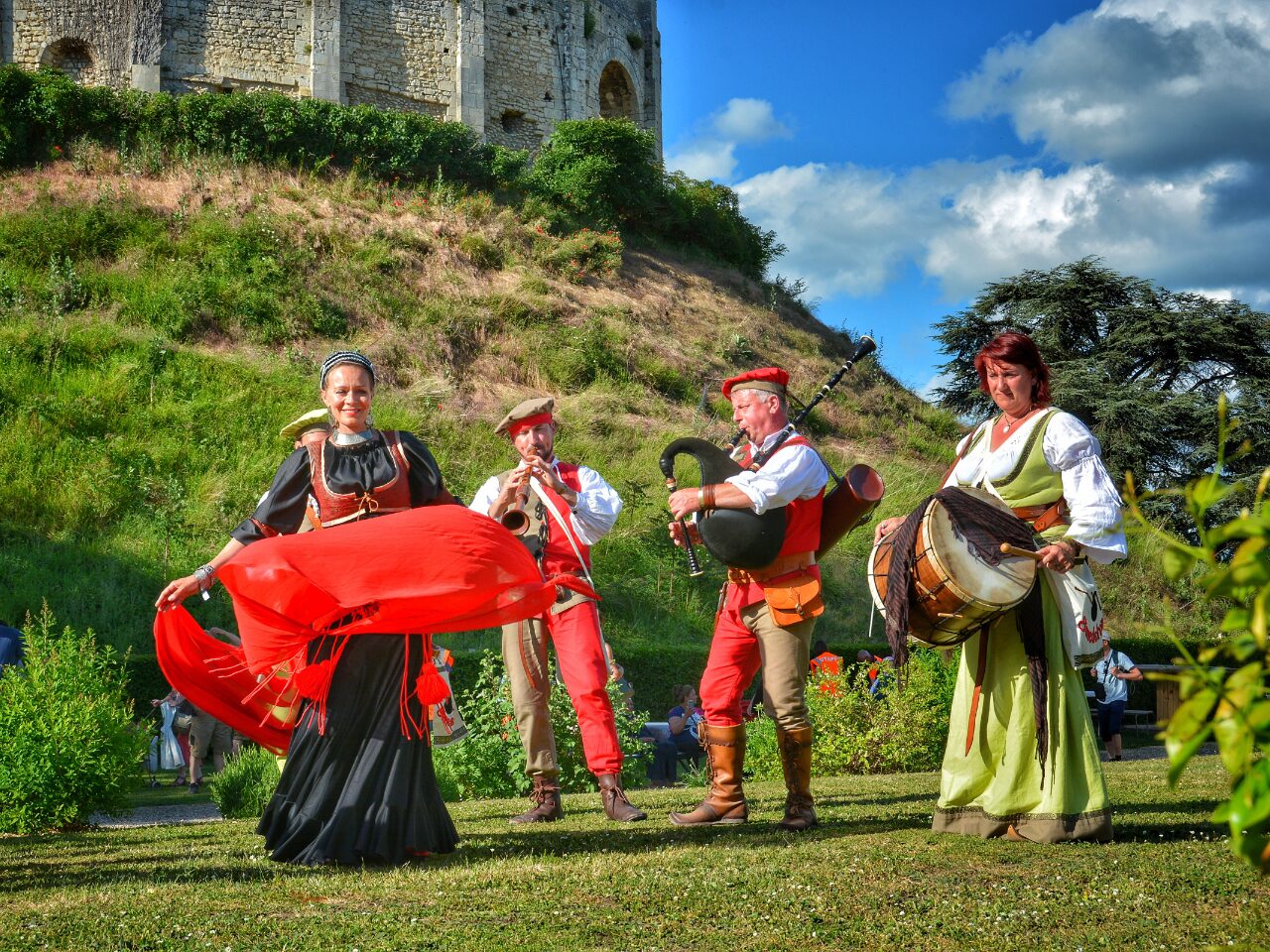 People at a festival, wearing medieval costumes, playing musical instruments