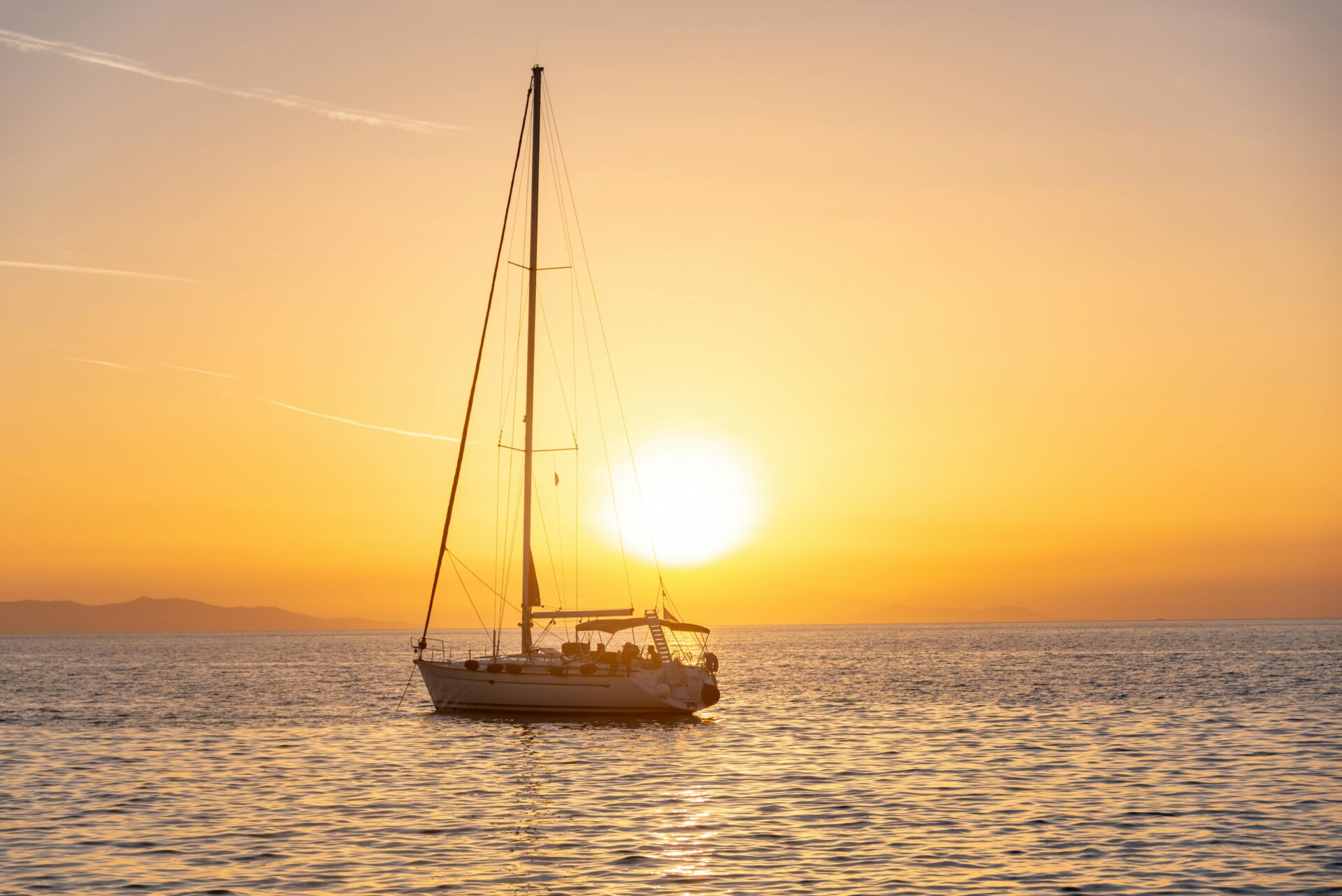 Photo of a Sailboat on the Sea during Sunset
