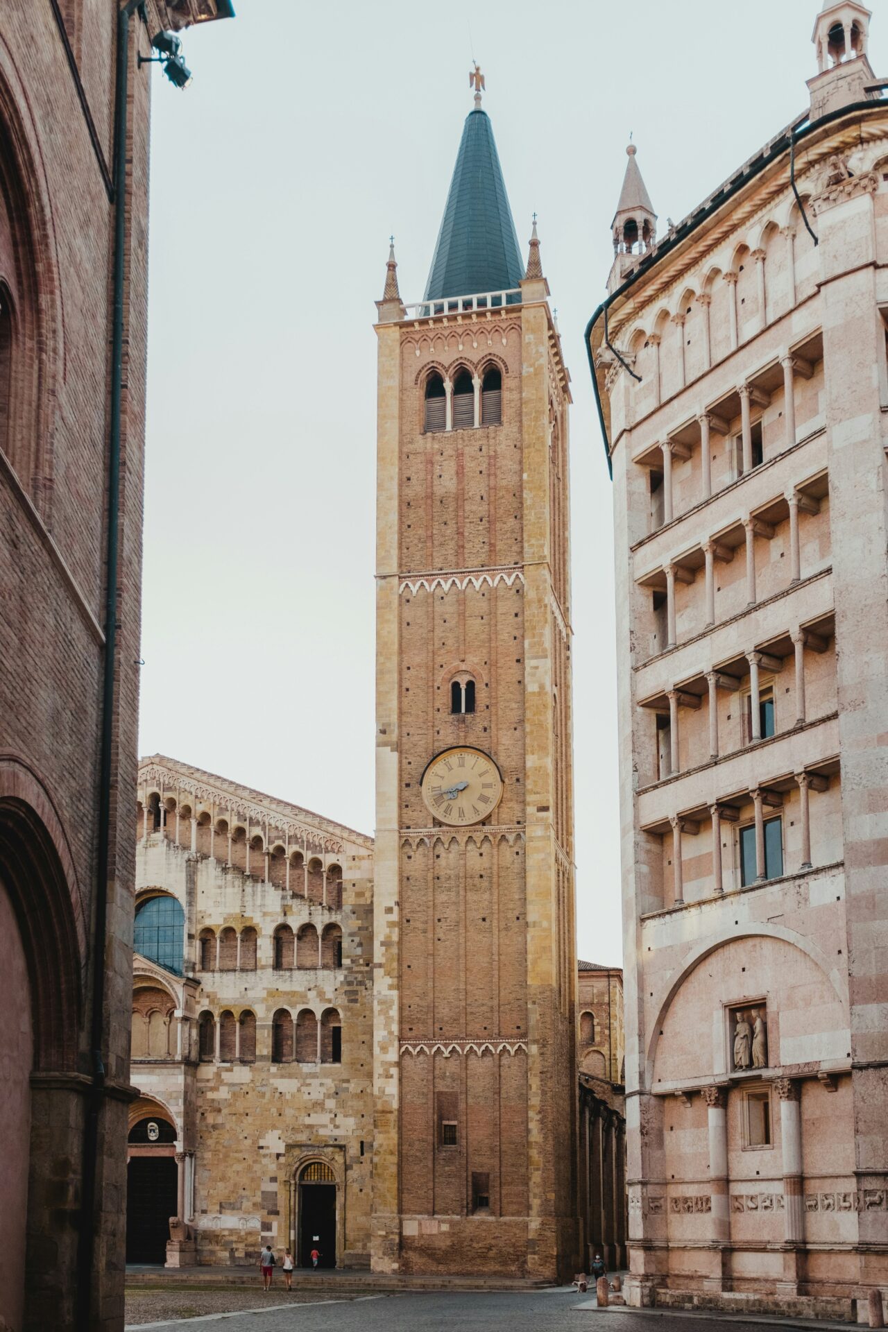 Piazza Duomo in Parma, Italy, featuring the stunning Parma Cathedral and Baptistery, showcasing Romanesque architecture in a historic square.