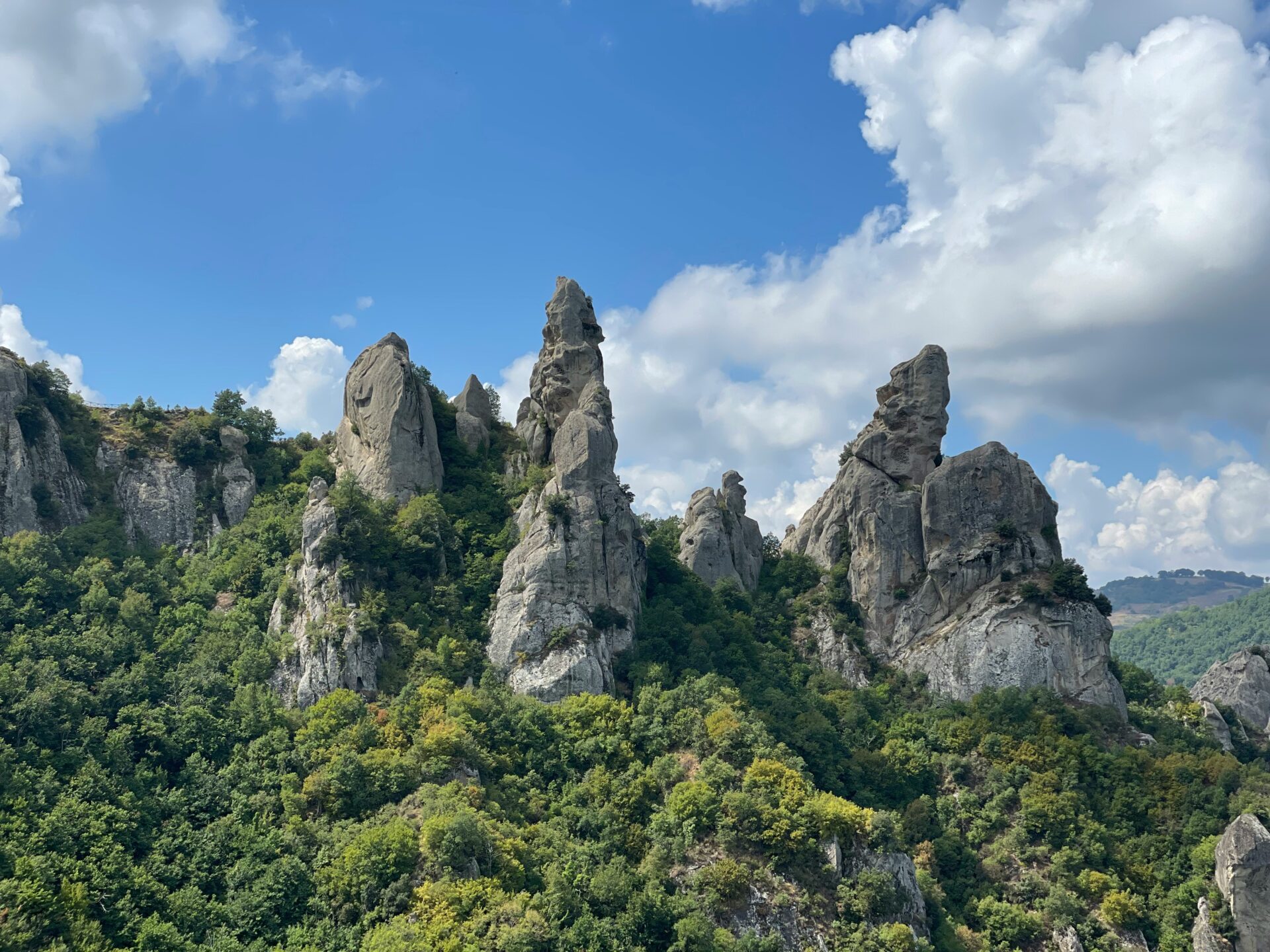 The jagged limestone peaks of the Dolomiti Lucane rise dramatically against a clear sky in southern Italy