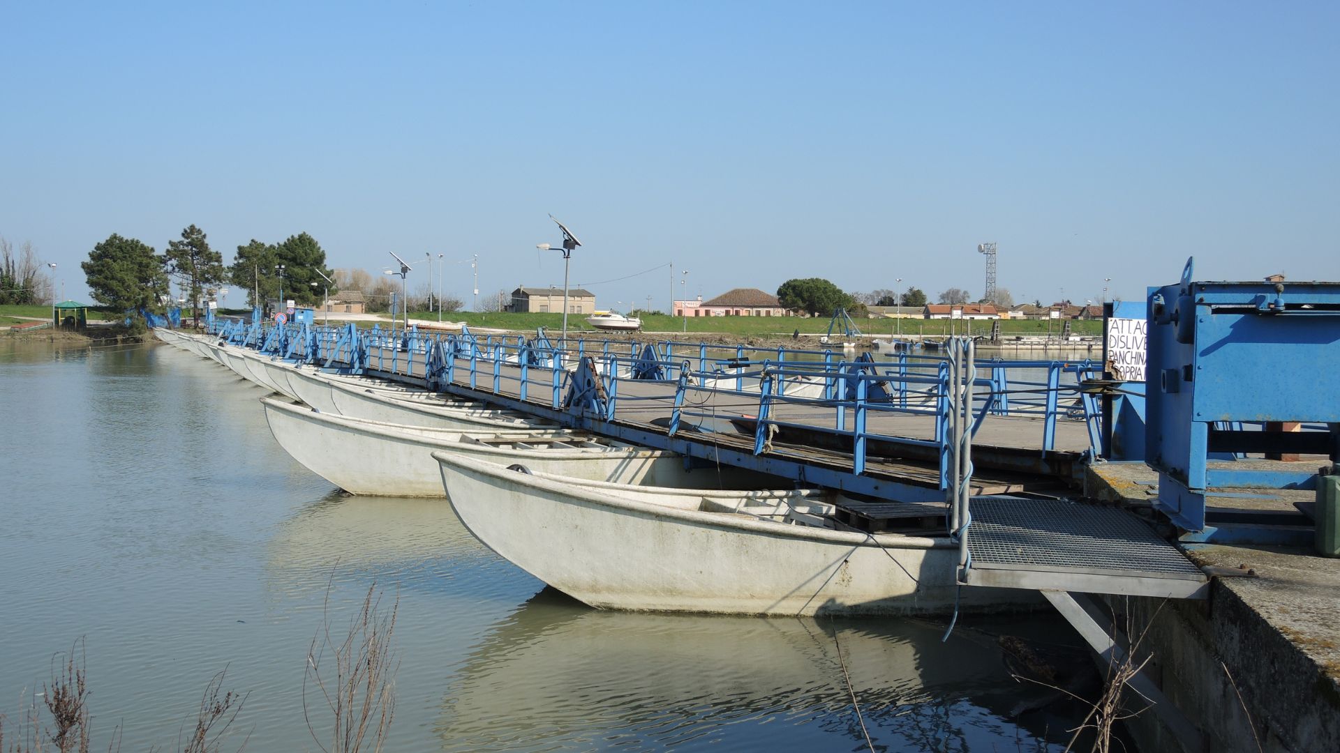 The image shows boats docked on the Po River in the Po Delta, near Venice, Italy.