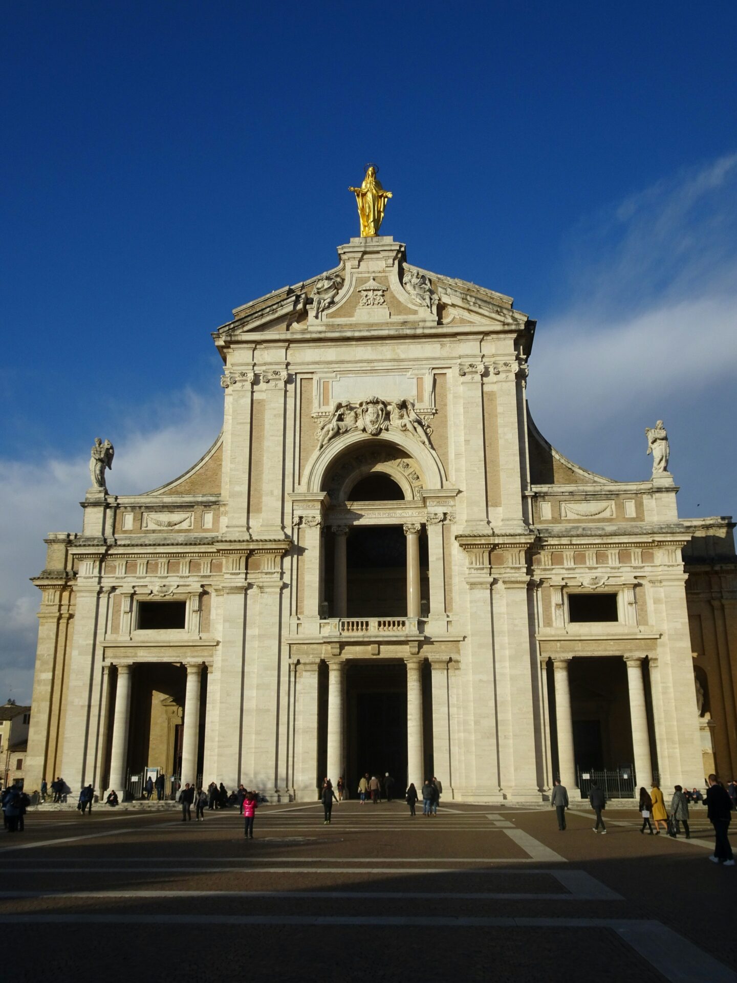 Portiuncula Chapel in Assisi, a small and humble stone structure with a simple gabled roof, nestled inside the grand Basilica of Santa Maria degli Angeli. 
