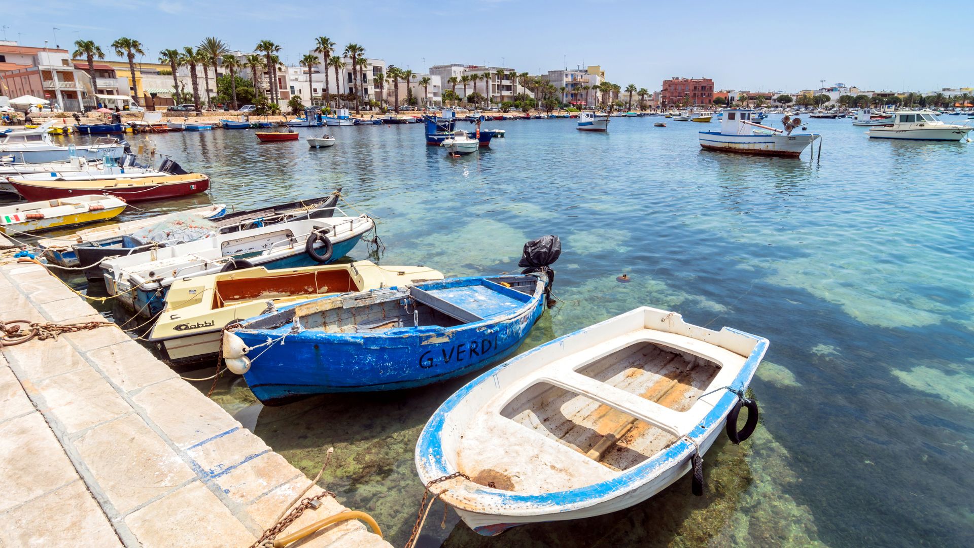 Image shows some boat on a pier in Porto Cesareo, Italy.