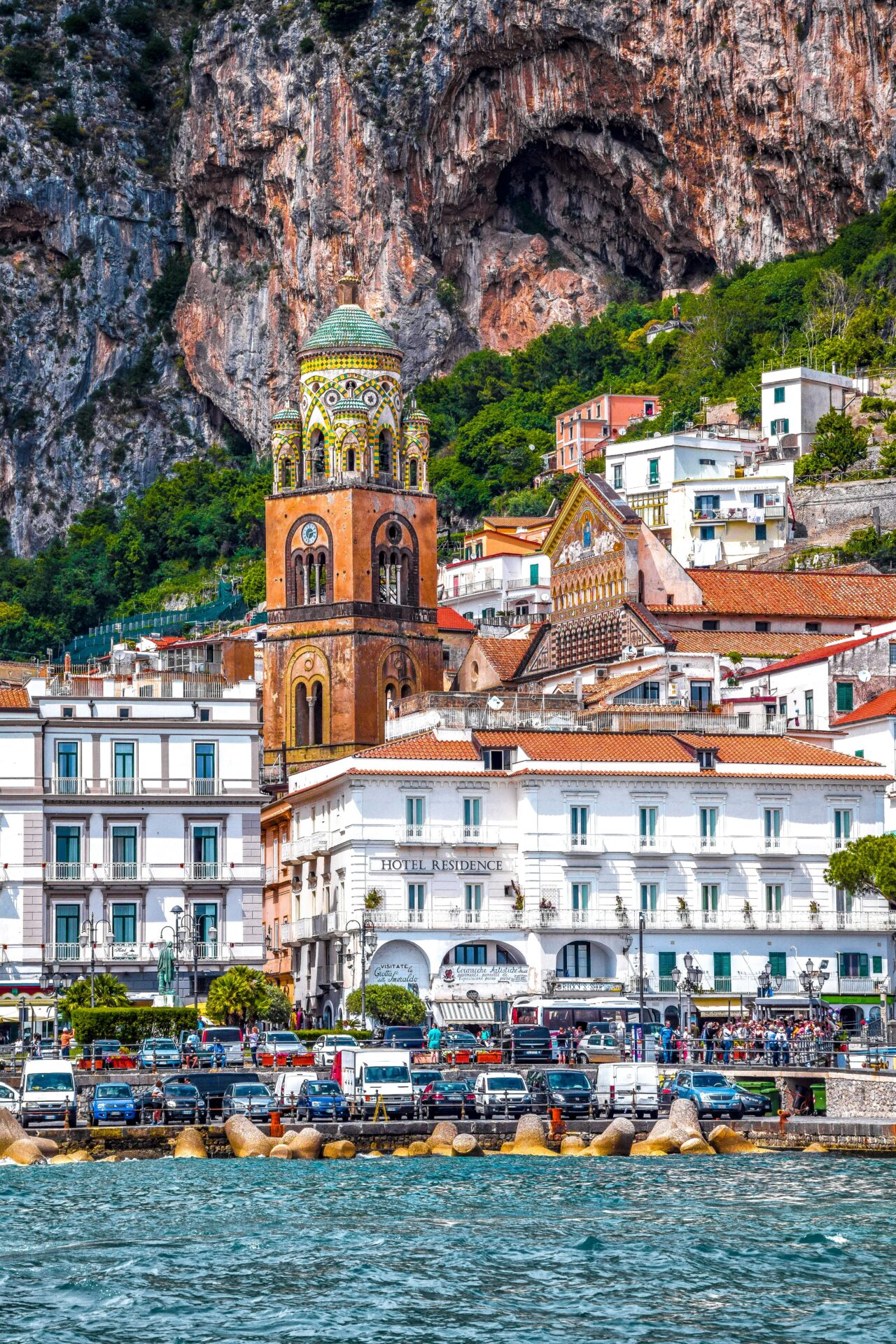 Colorful buildings and the bell tower of Amalfi Cathedral against the dramatic cliffs in Ravello, Salerno, Italy.