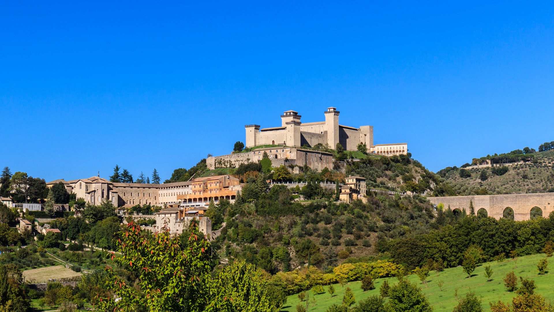 The image shows the Rocca Albornoziana fortress in Spoleto, Italy