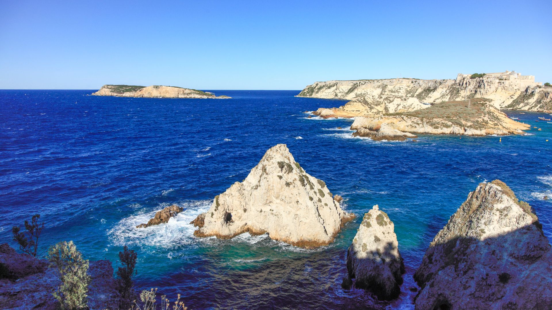 The image shows San Nicola, Tremiti Islands, Italy characterized by clear turquoise waters, and rocky cliffs. 