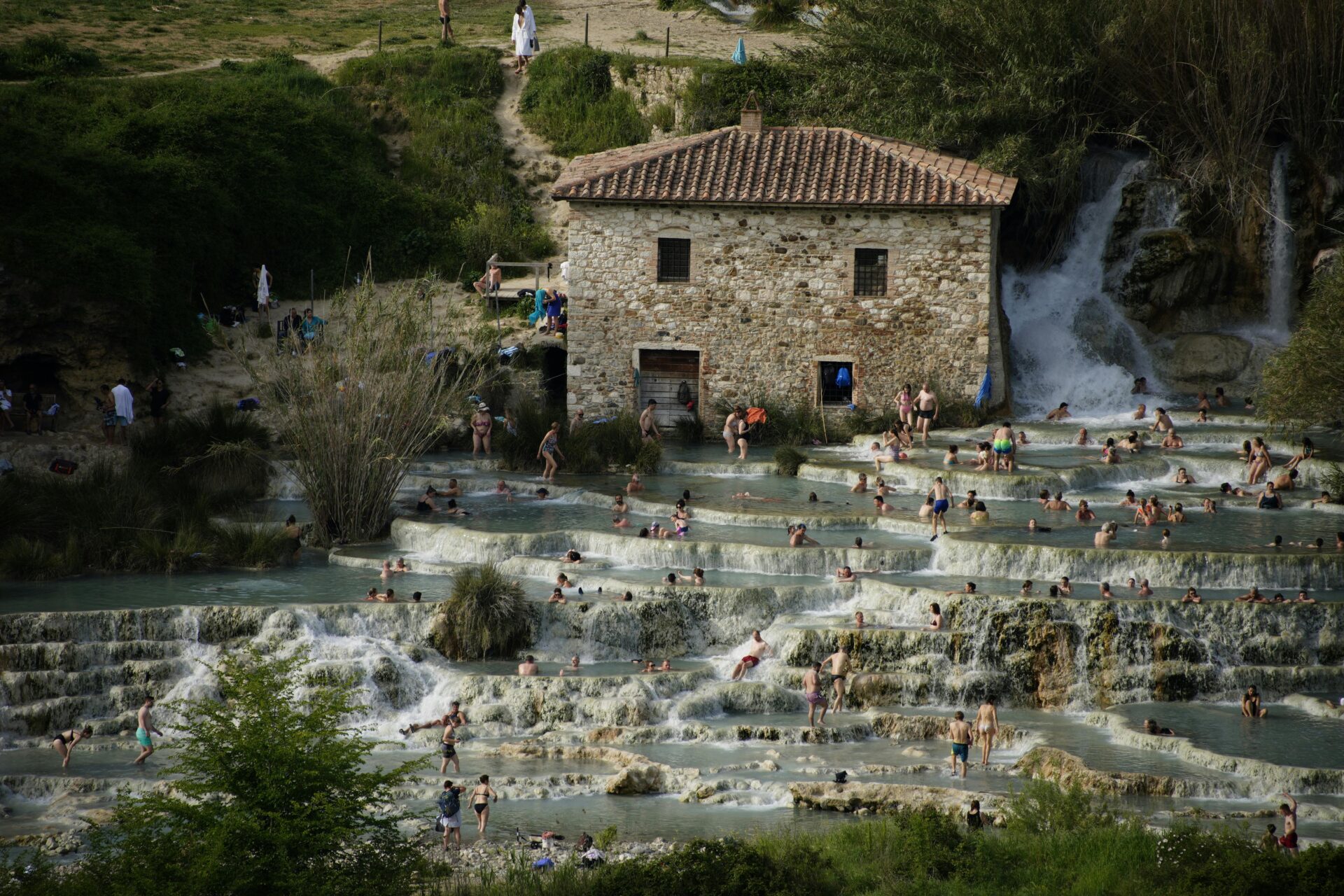 Crowds of people enjoying the warm, mineral-rich waters of Saturnia’s thermal cascades