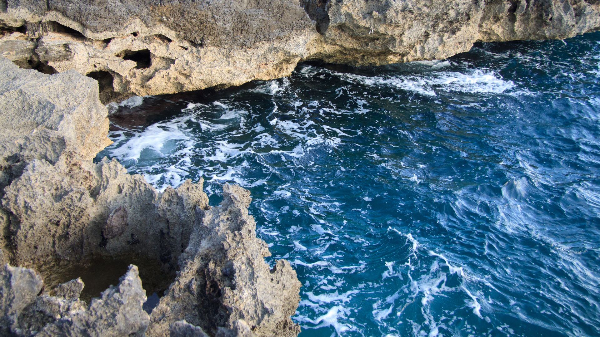 Image shows deep blue water and rocky cliffs of Torre Inserraglio, Porto Cesareo Marine Protected Area (MPA) in Puglia, Italy