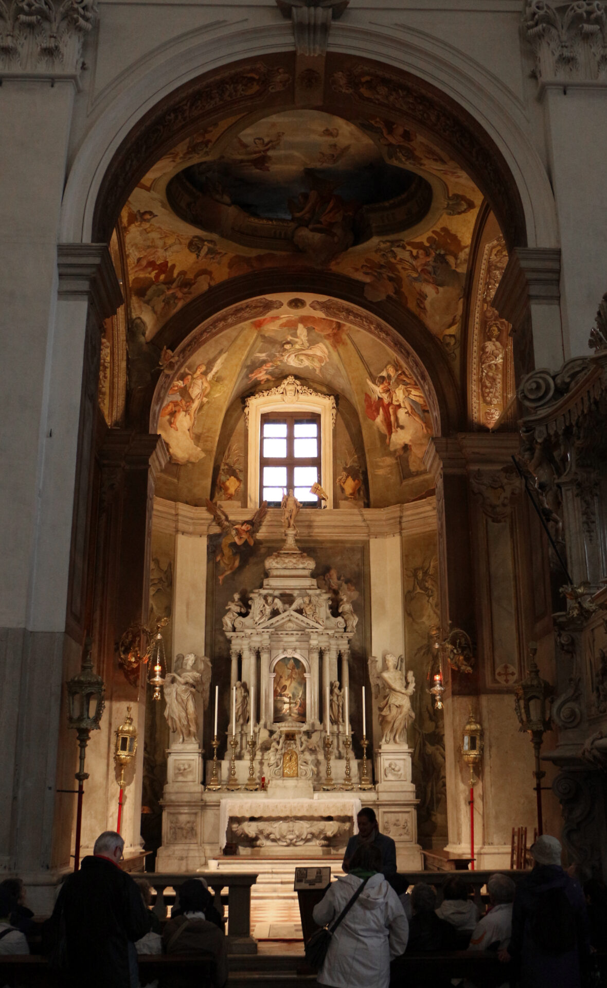 Ornate altar inside Udine Cathedral, featuring intricate Baroque details, religious sculptures, and paintings, including works by Giovanni Battista Tiepolo.