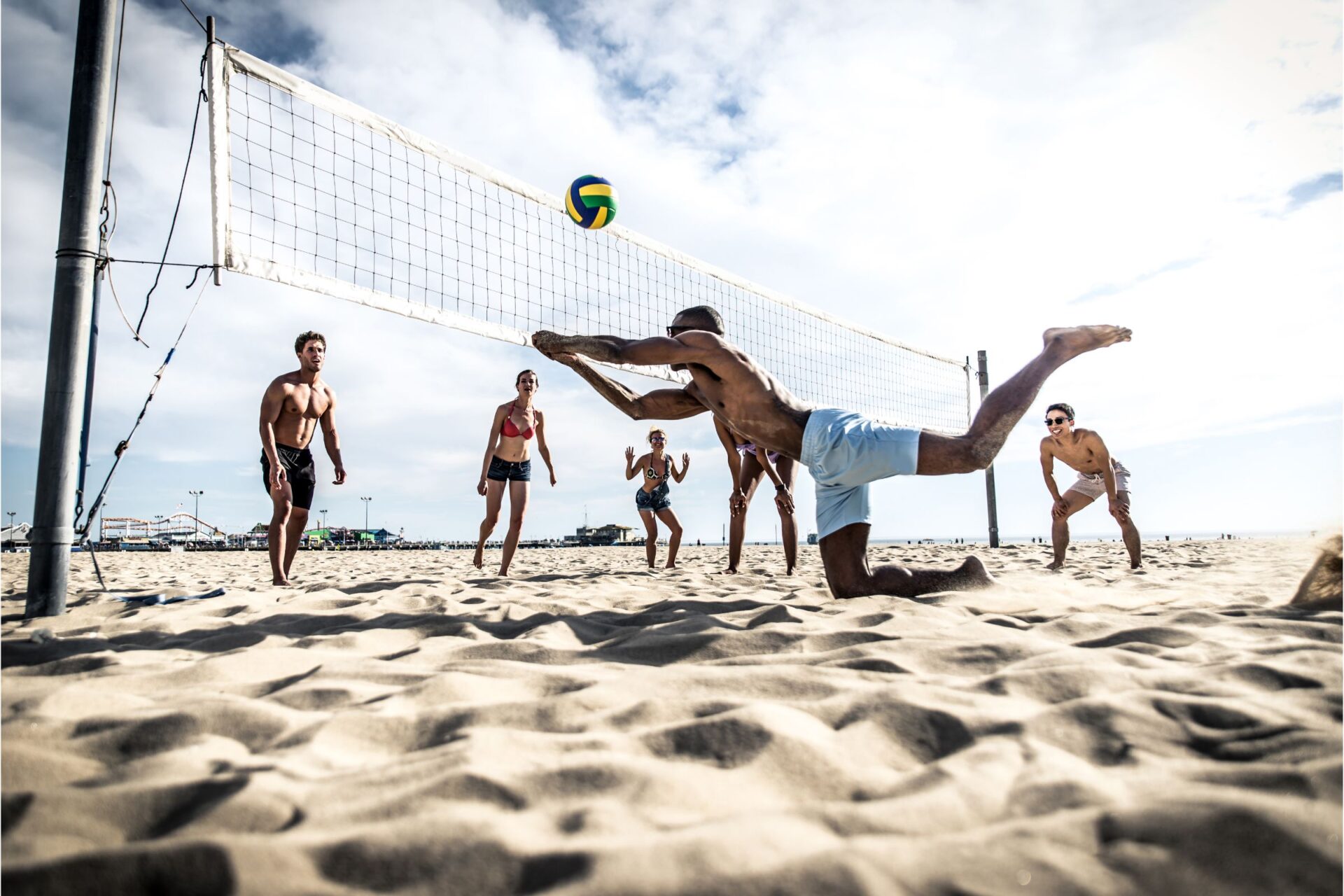 people playing volleyball on the beach