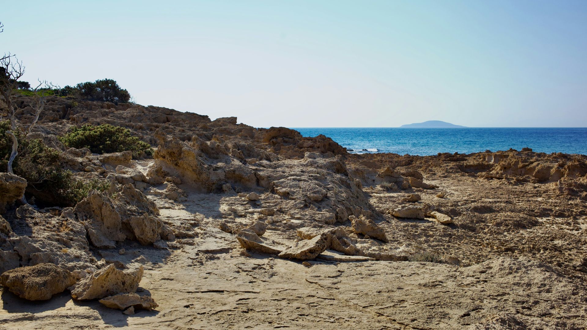 Agios Ioannis Beach on Gavdos Island in Crete, Greece featuring rocky beach with blue ocean and sky.