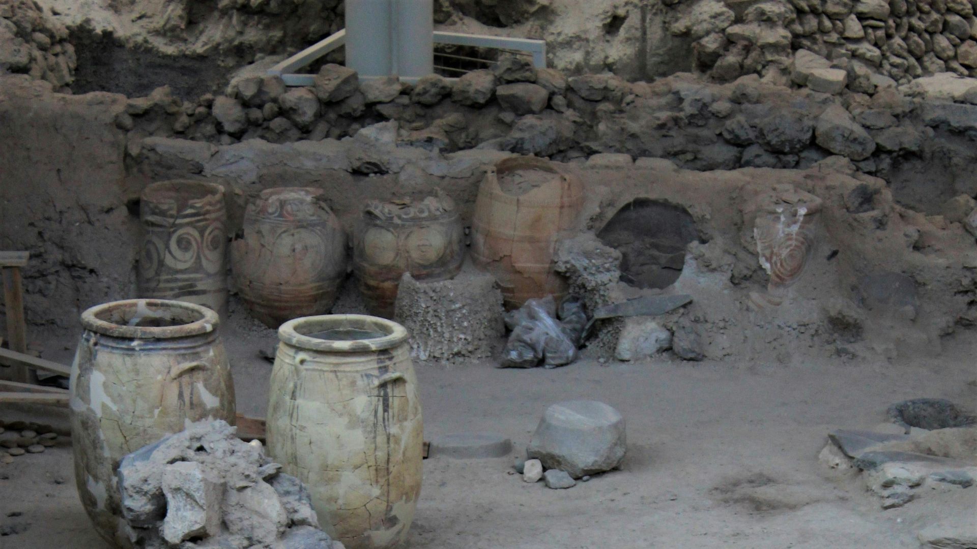 Archaeological site of Akrotiri, Santorini, Greece, showing ancient ruins and pots.