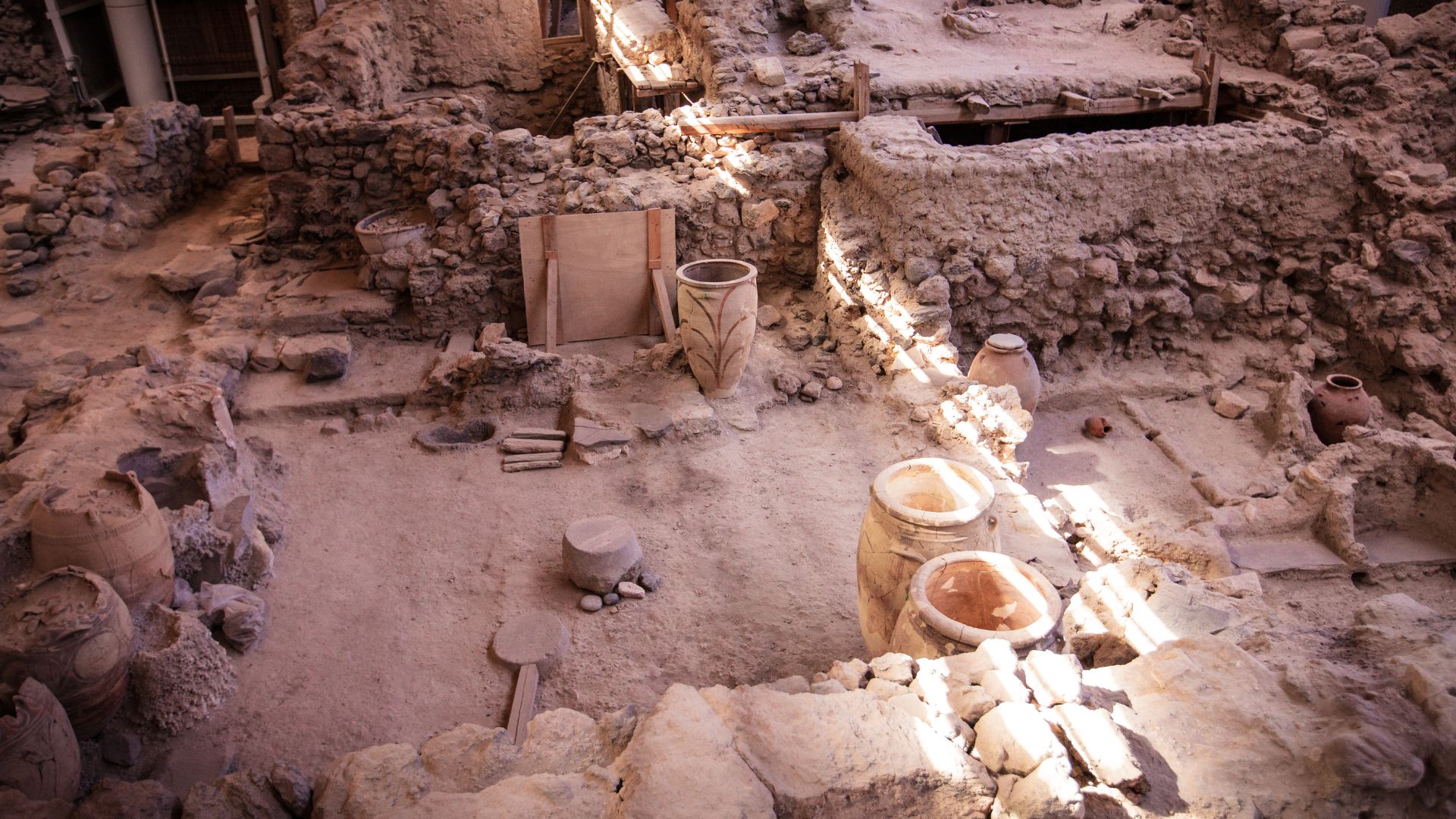 Archaeological site of Akrotiri, Santorini, Greece, showing ancient ruins and jars.