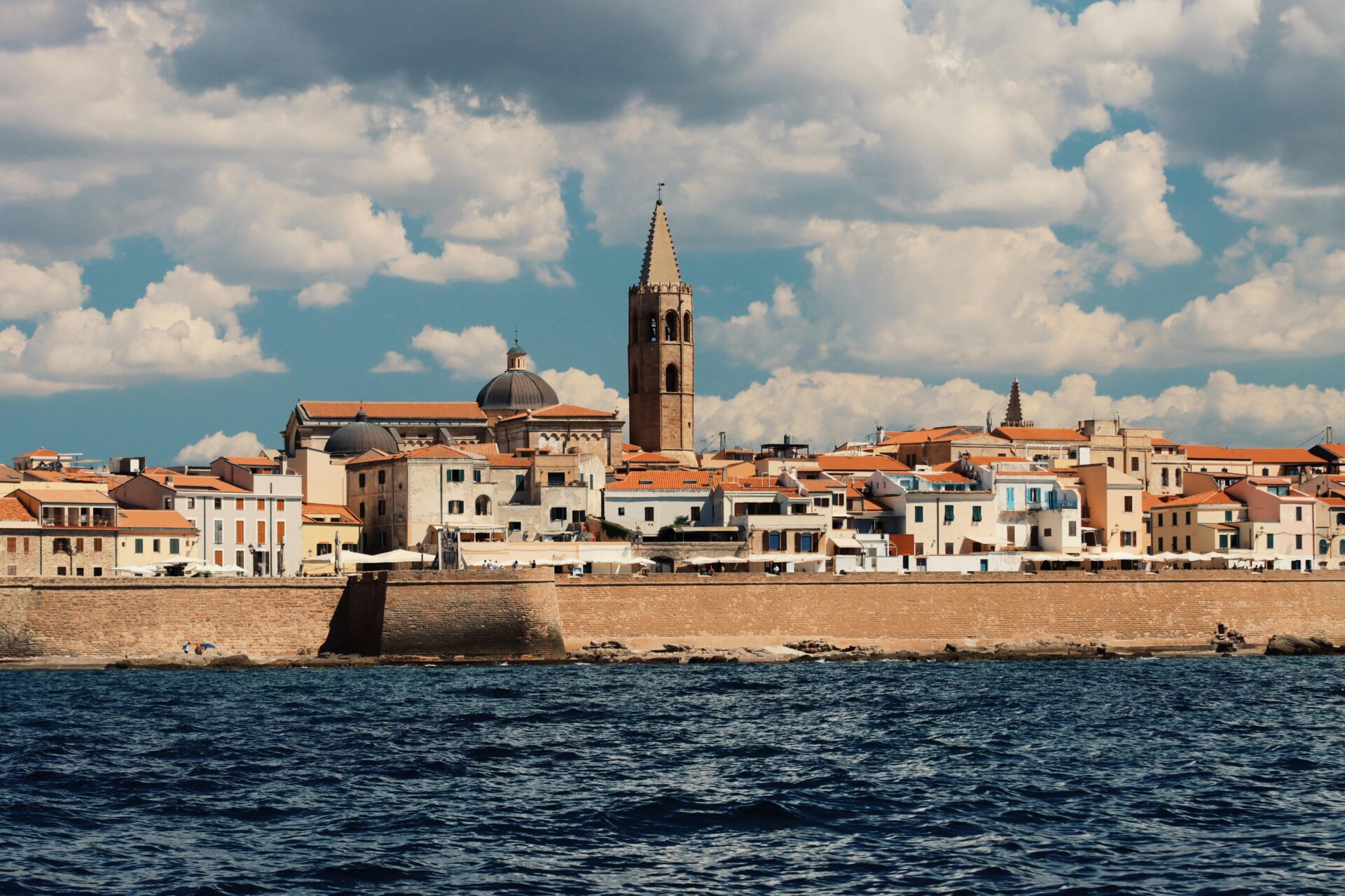 lghero’s waterfront with its ancient sea wall stretching along the coast
