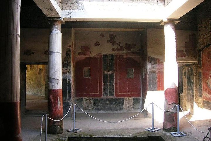 Interior view of a frescoed room with columns at the archaeological site of Ancient Stabiae, Italy.